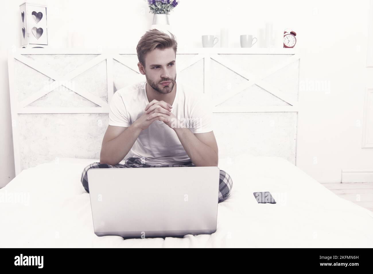 Online work from home computer. Unshaven man use laptop in bed ...