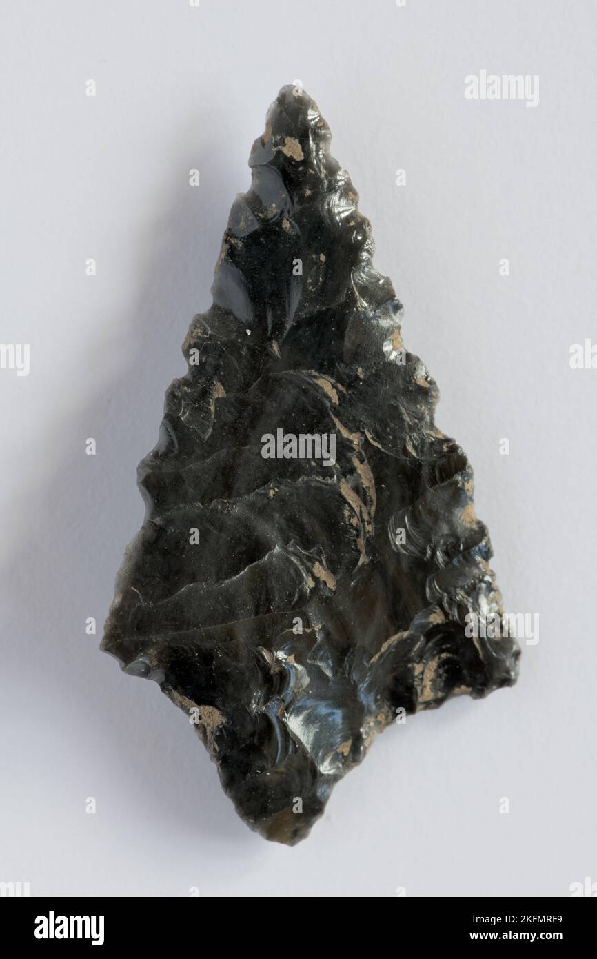 Neolithic obsidian arrowhead on white background Stock Photo