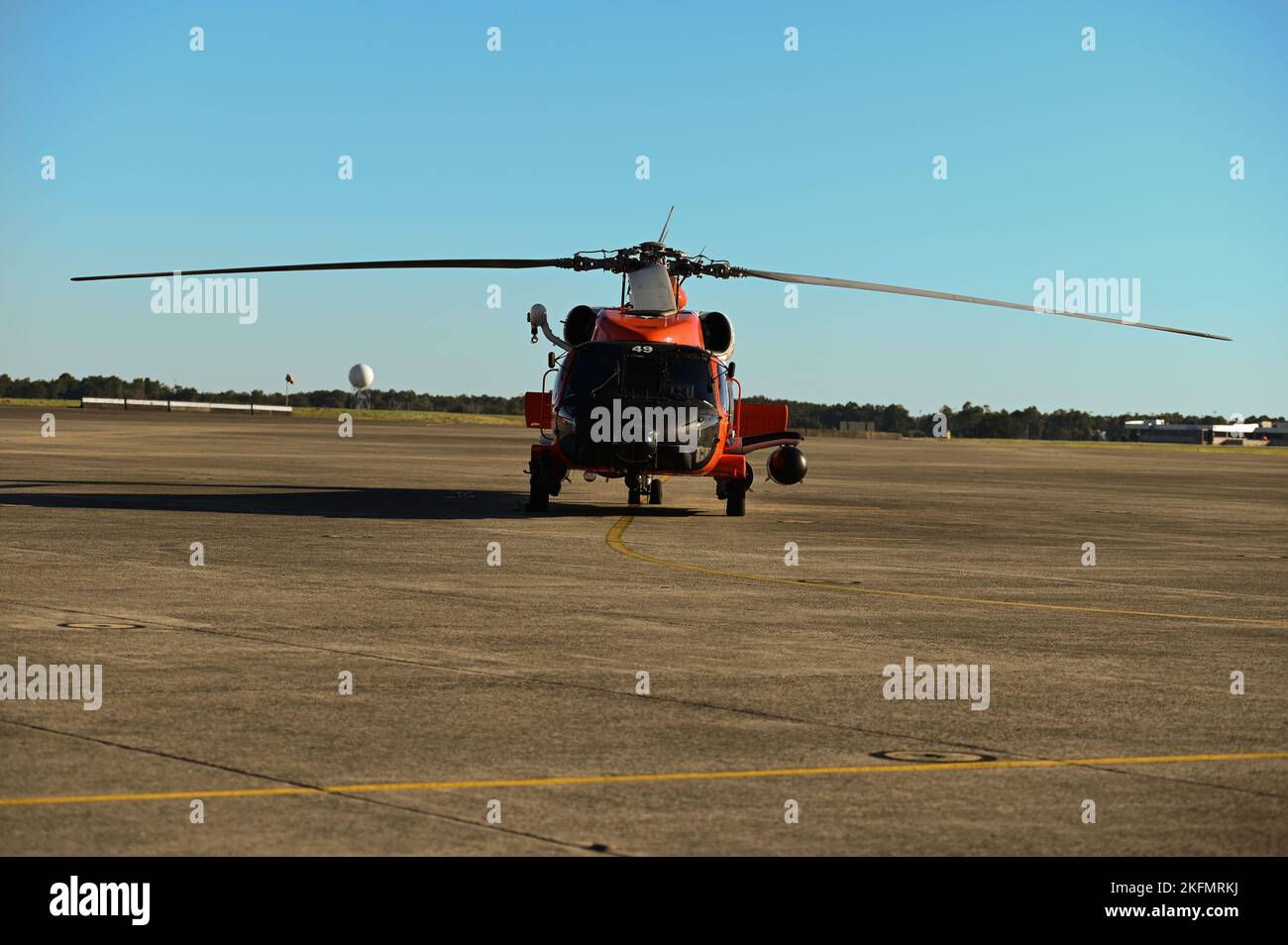 A Coast Guard MH-60 Jayhawk helicopter is staged on the tarmac Sept. 27, 2022, at Coast Guard Aviation Training Center Mobile, Alabama. Coast Guard assets are being staged outside of the predicted path of Hurricane Ian at Aviation Training Center Mobile. Stock Photo