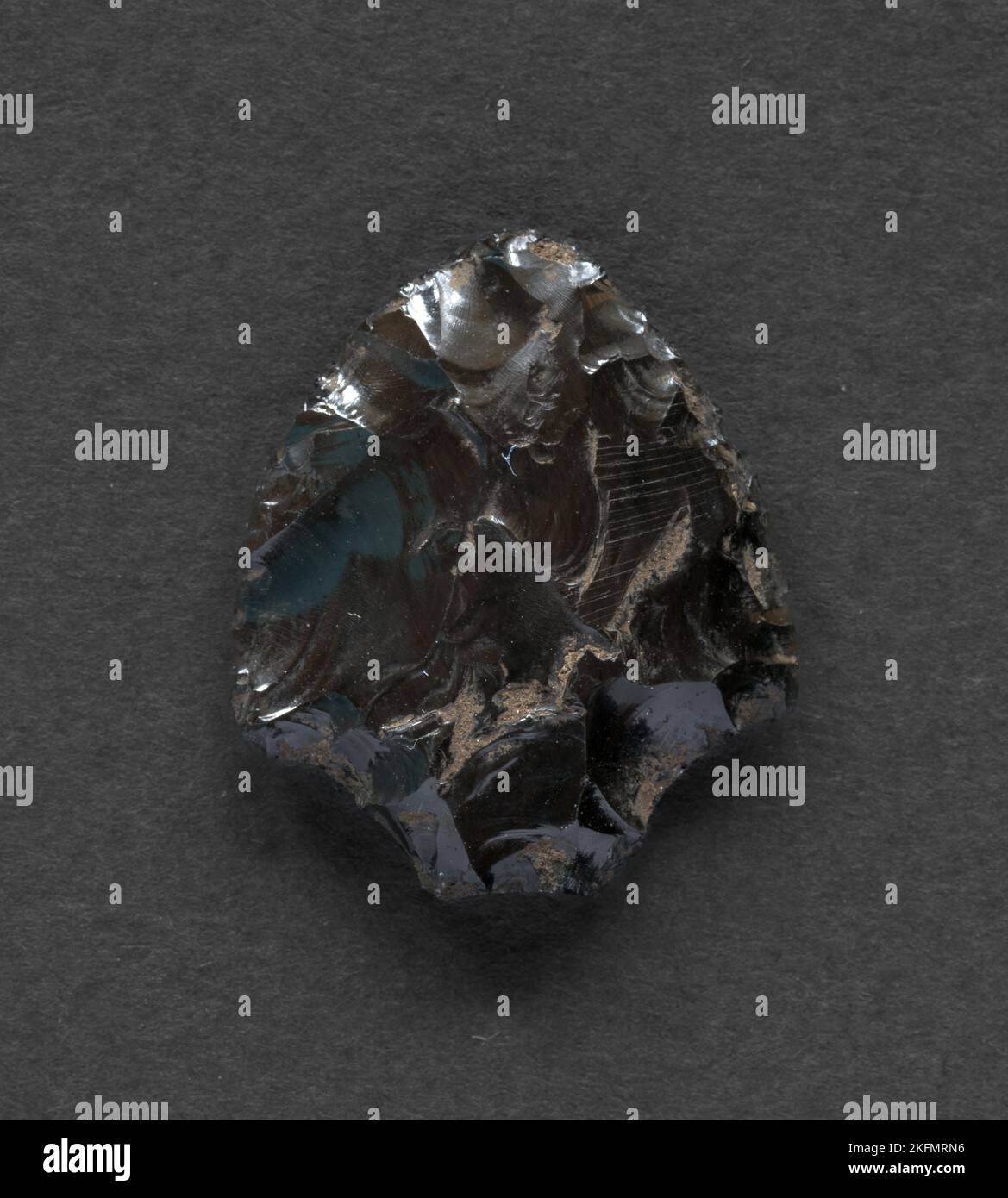 Neolithic obsidian arrowhead on dark background Stock Photo