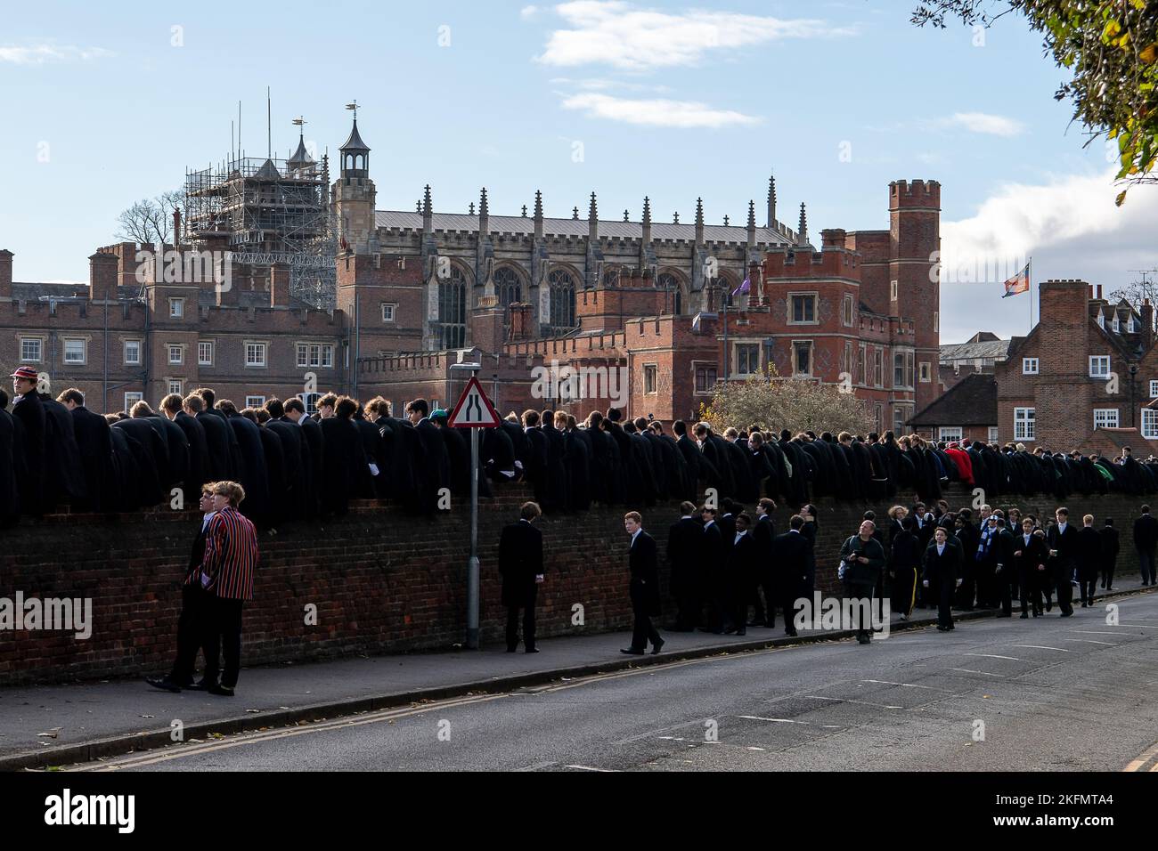 Eton, Windsor, Berkshire, UK. 19th November, 2022. It was a busy day today in Eton for the famous Eton College Wall Game. The game originated at and is still played at Eton College. It is celebrated each year on St Andrew's Day. Eton College boys sit on the wall and cheer on the players. It is played on a strip of ground 5 metres wide and 110 metres long next to a slightly curved brick wall that was erected in 1717. It is one of two codes of football played at Eton, the other being the Eton Field Game. Former pupils Prince Harry and The Duke of Cornwall were pupils at the school as was Boris J Stock Photo