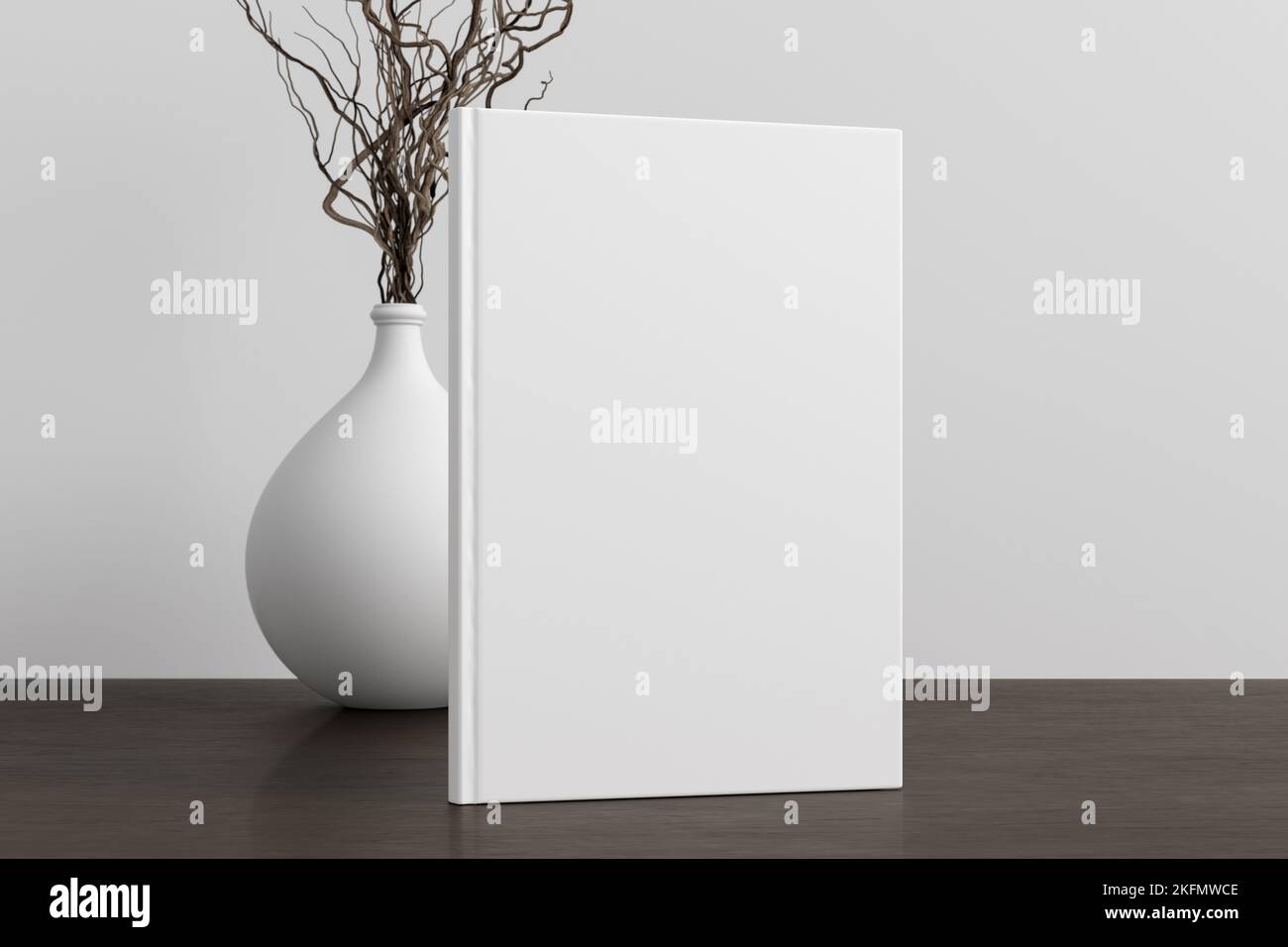 Vertical book cover mock up standing on a dark wooden desk with white wall background Stock Photo