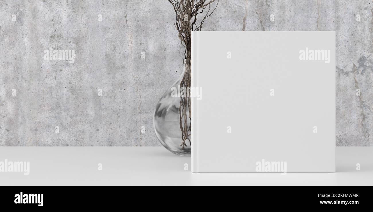Square book cover mock up standing on a white desk with concrete wall background Stock Photo