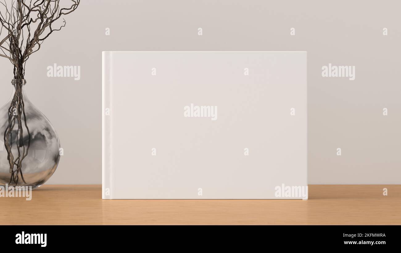Horizontal book cover mock up standing on a wooden desk with white wall background Stock Photo