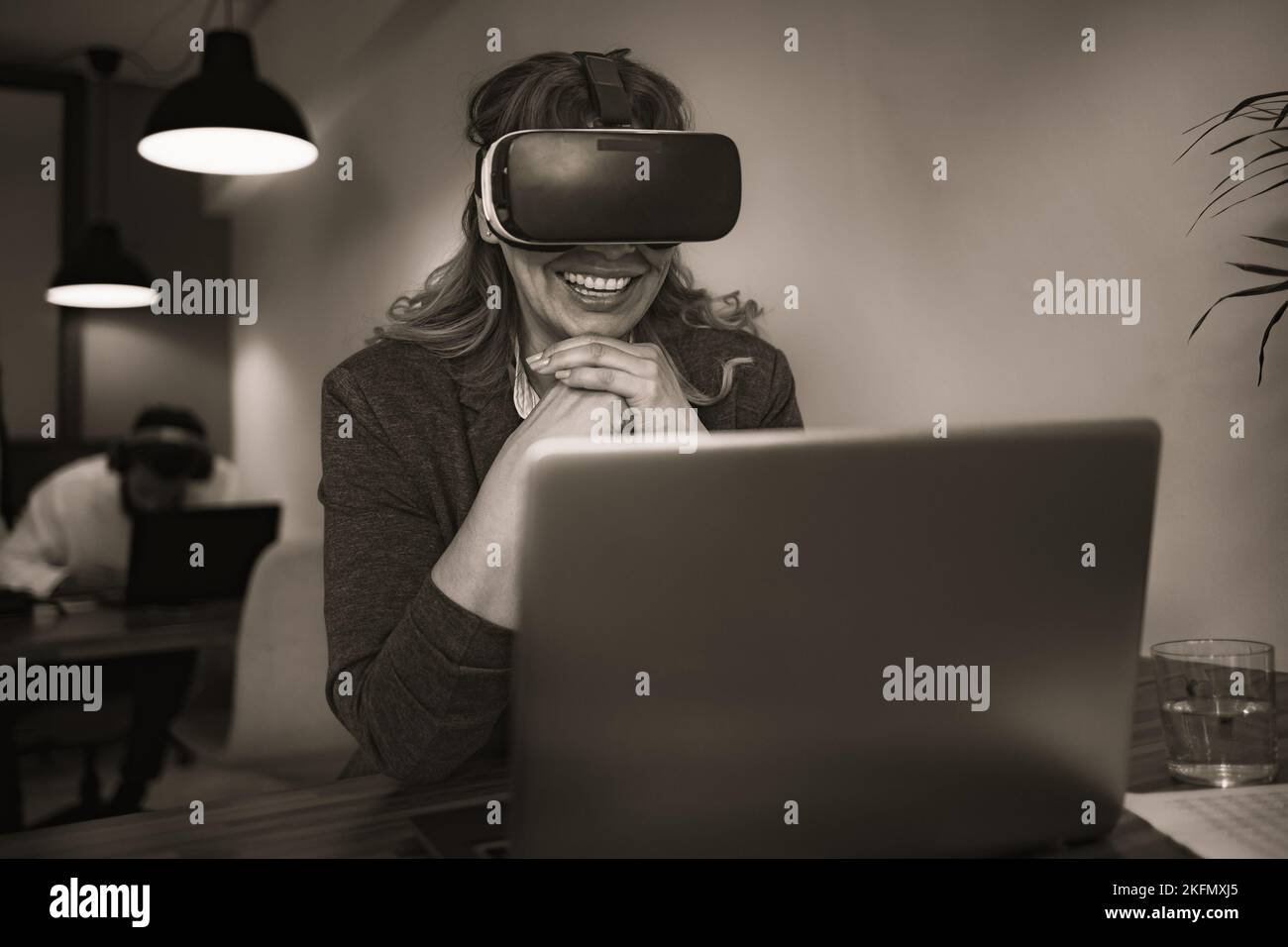 Business woman working with futuristic virtual reality glasses in modern coworking creative space - Technology and innovation concept Stock Photo