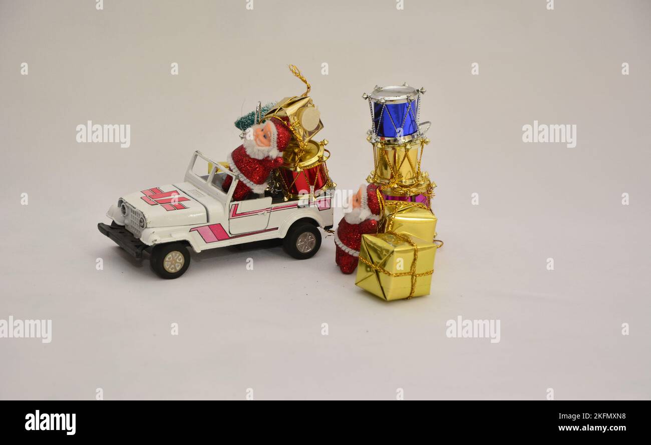 Santa Claus putting gifts in the wheel drive car. Selective focus. Brazil, South America, White background Stock Photo