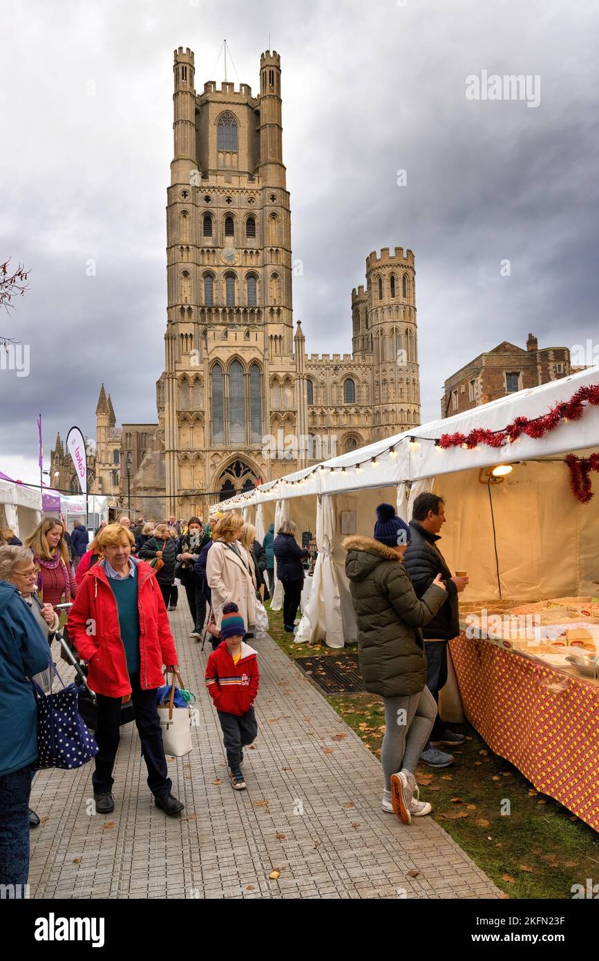 Ely UK; Ely Cathedral Christmas fair - people shopping outside at the food and gift market stalls at Xmas, Ely Cambridgeshire UK Stock Photo