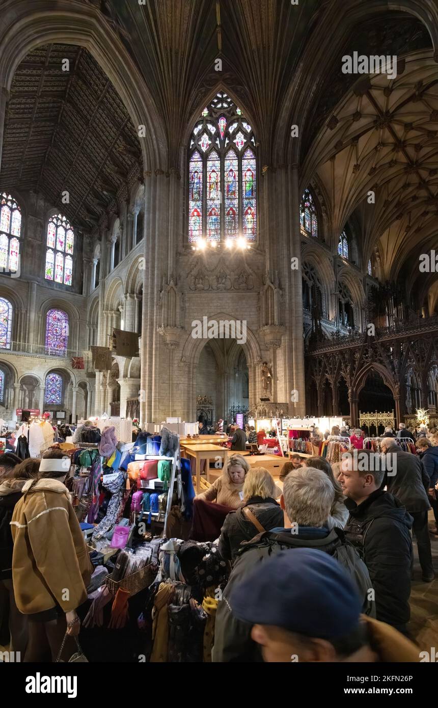 Ely Cathedral Christmas fair - people shopping at food and gift market stalls at Xmas, inside the cathedral, Ely Cambridgeshire UK Stock Photo