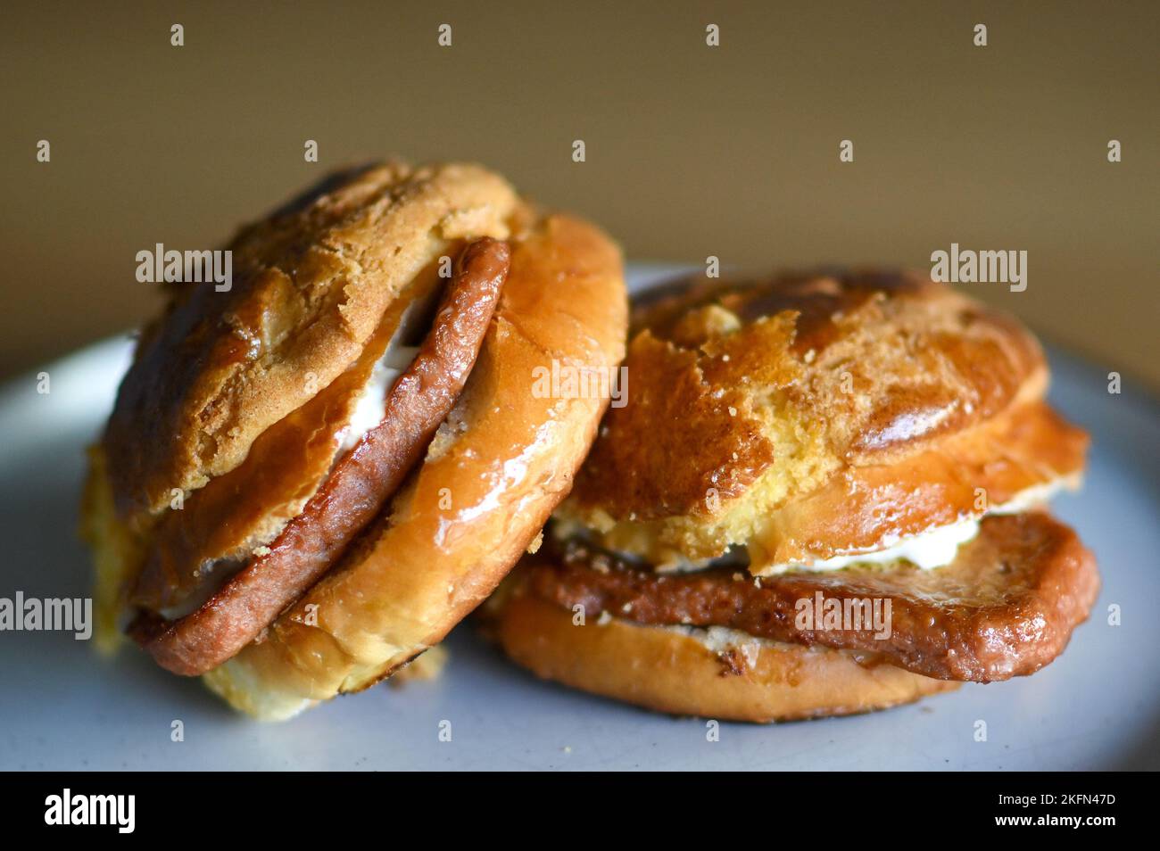 Bolo Bum or Pineapple Bun with a vegetarian "Meat" slice inside. London. UK. November 2022 Stock