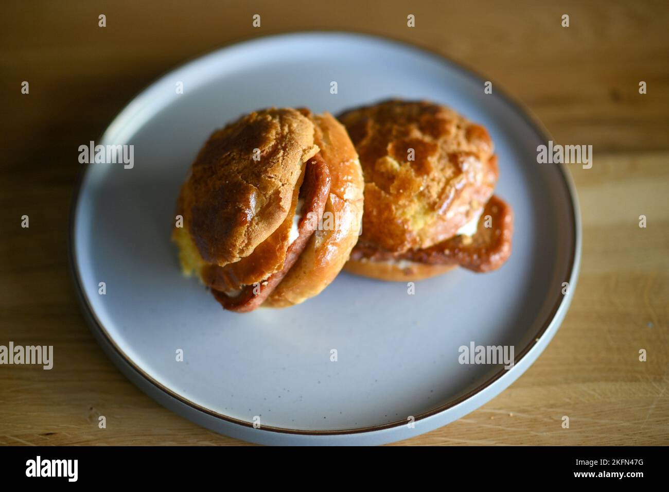 Bolo Bum or Pineapple Bun with a vegetarian "Meat" slice inside. London. UK. November 2022 Stock