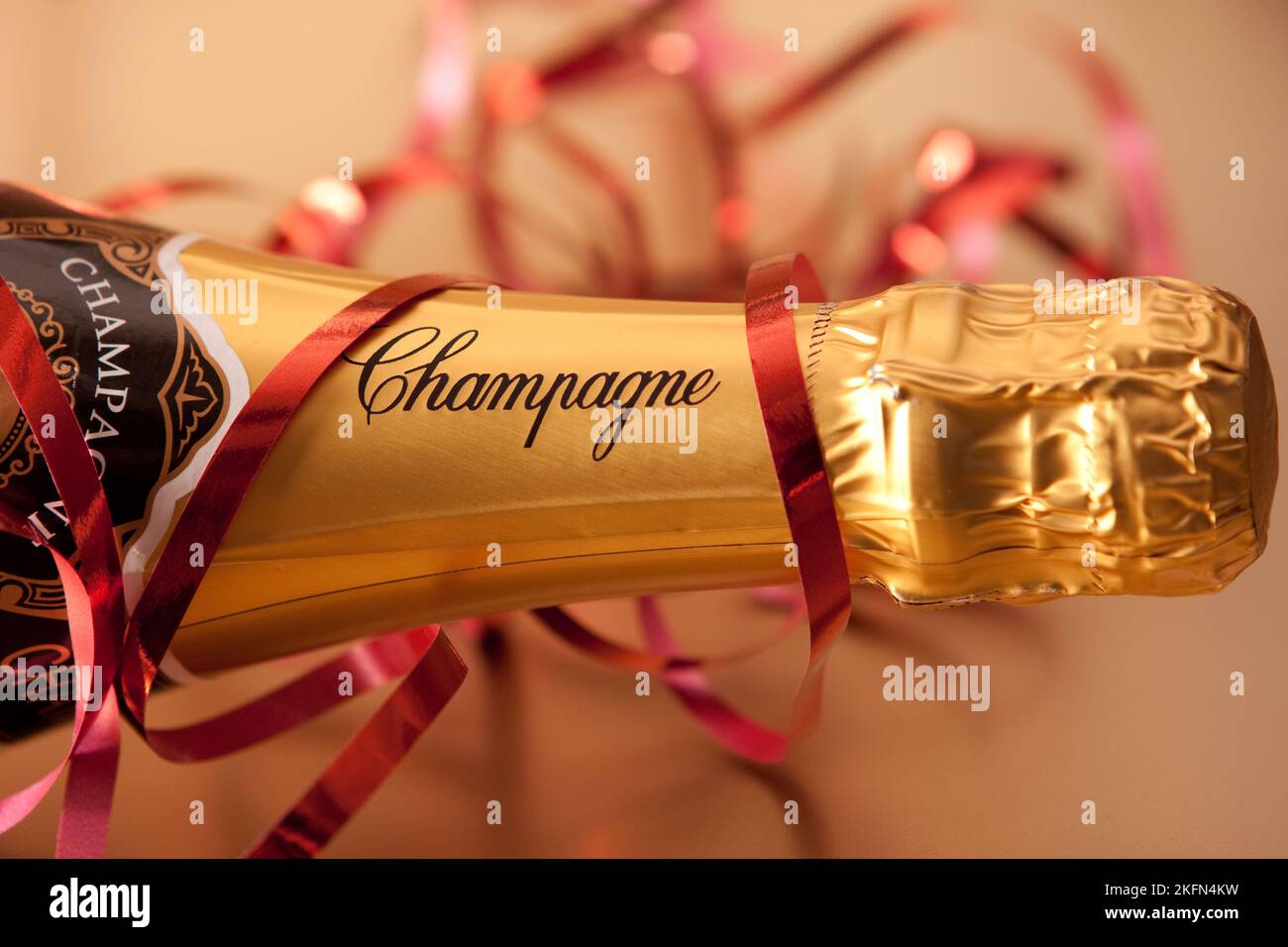 A bottle of champagne and red ribbon, with focus on the label Stock Photo