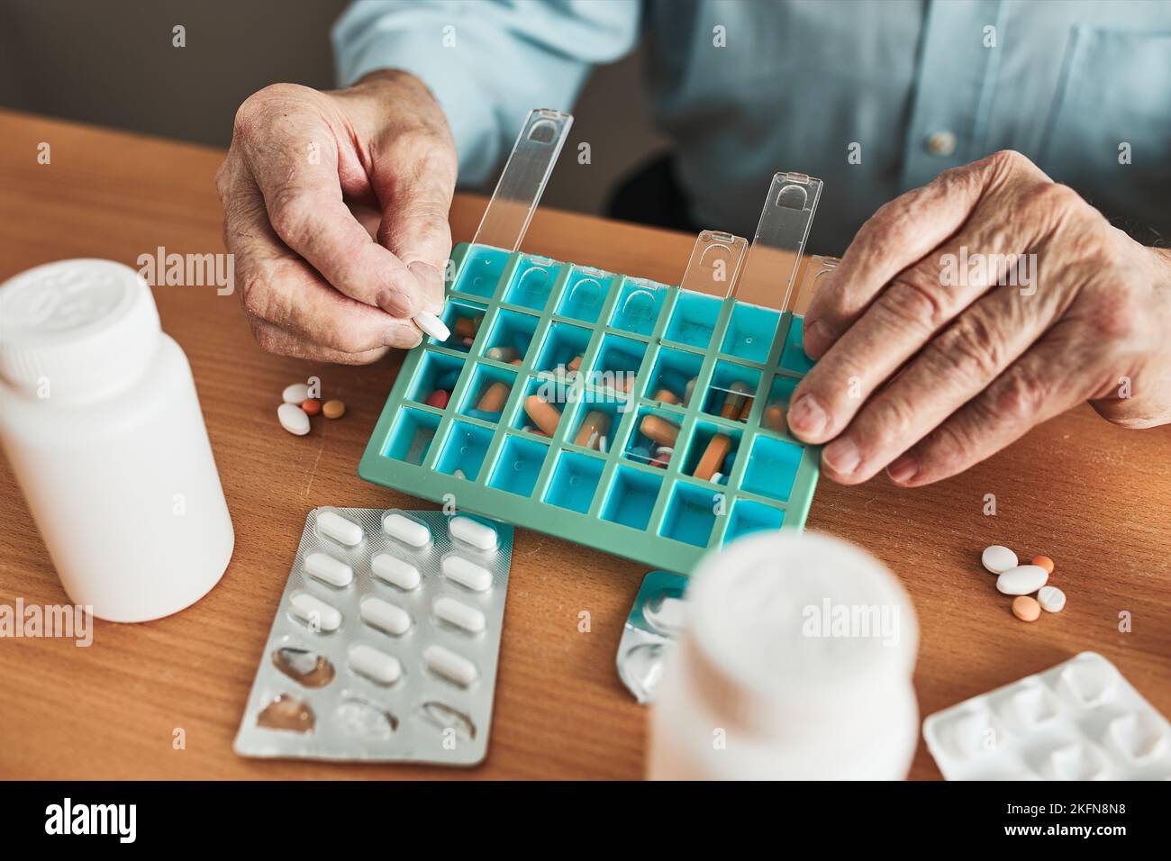 Senior man organizing his medication into pill dispenser. Senior man