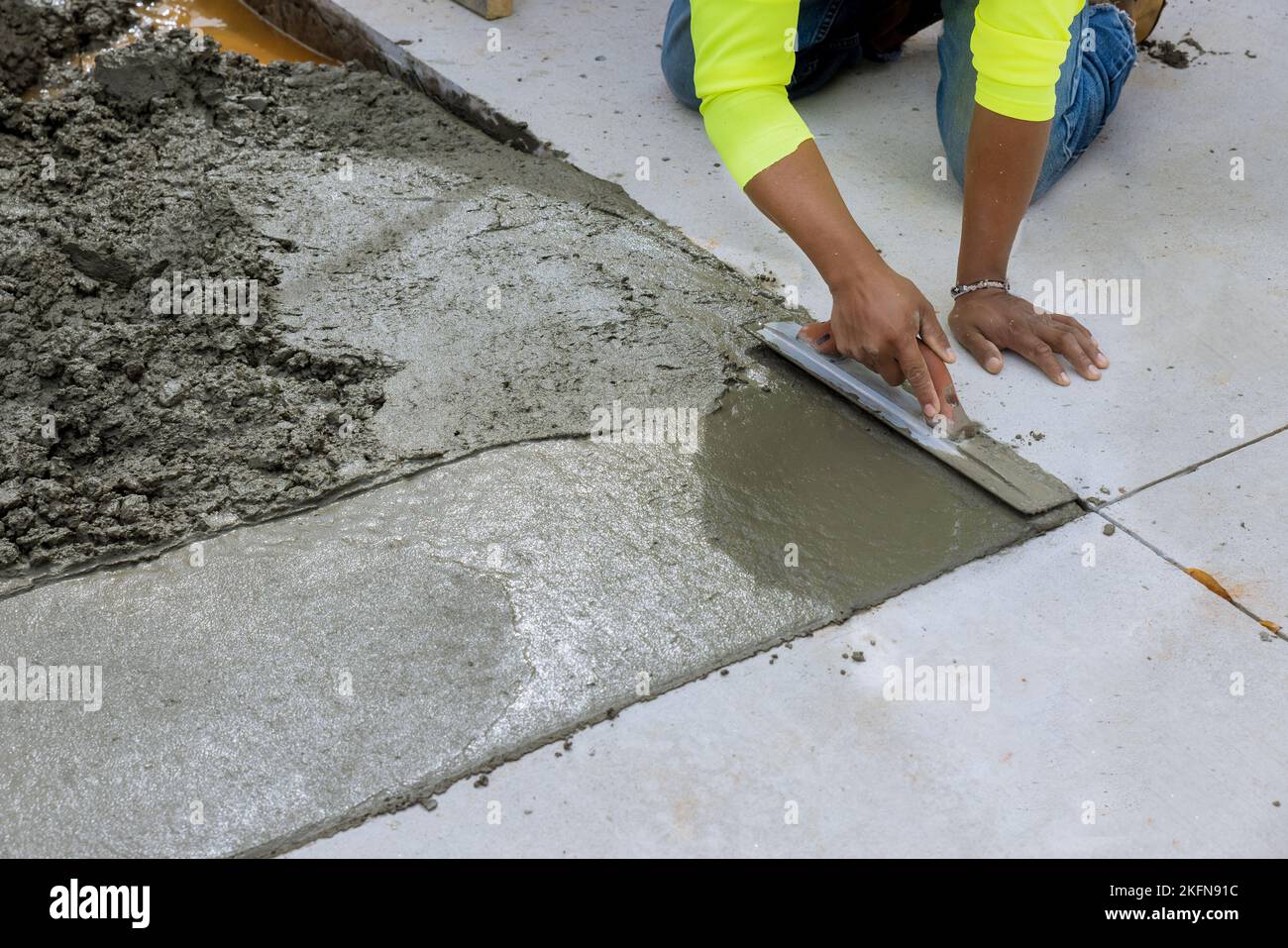 During construction worker is holding steel trowel to smooth out