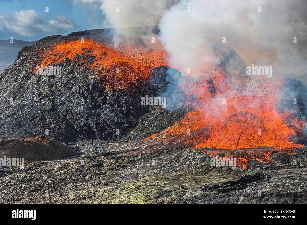 active volcano on Iceland. Eruption with lava flow from a volcanic crater on the Reykjanes peninsula. Glowing hot lava with a small fountain. Stock Photo