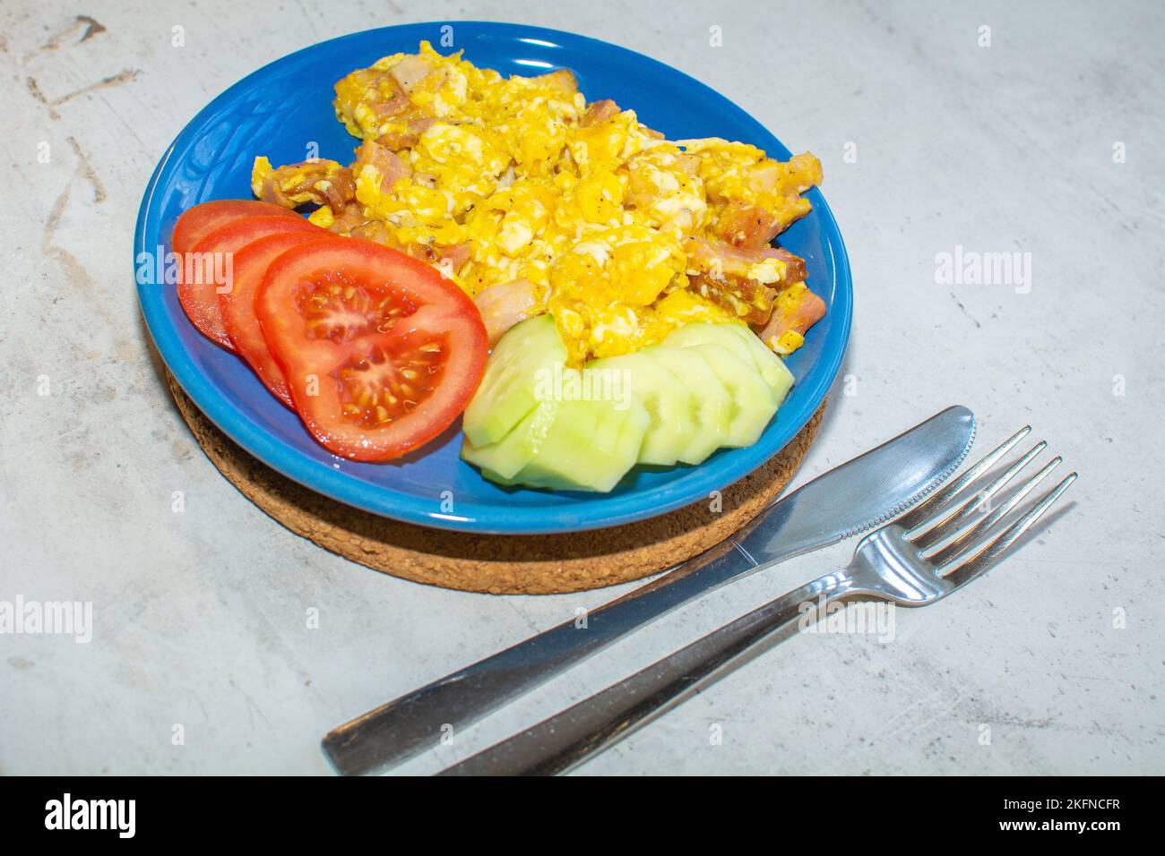 Scrambled eggs with bacon in a pan. Stock Photo