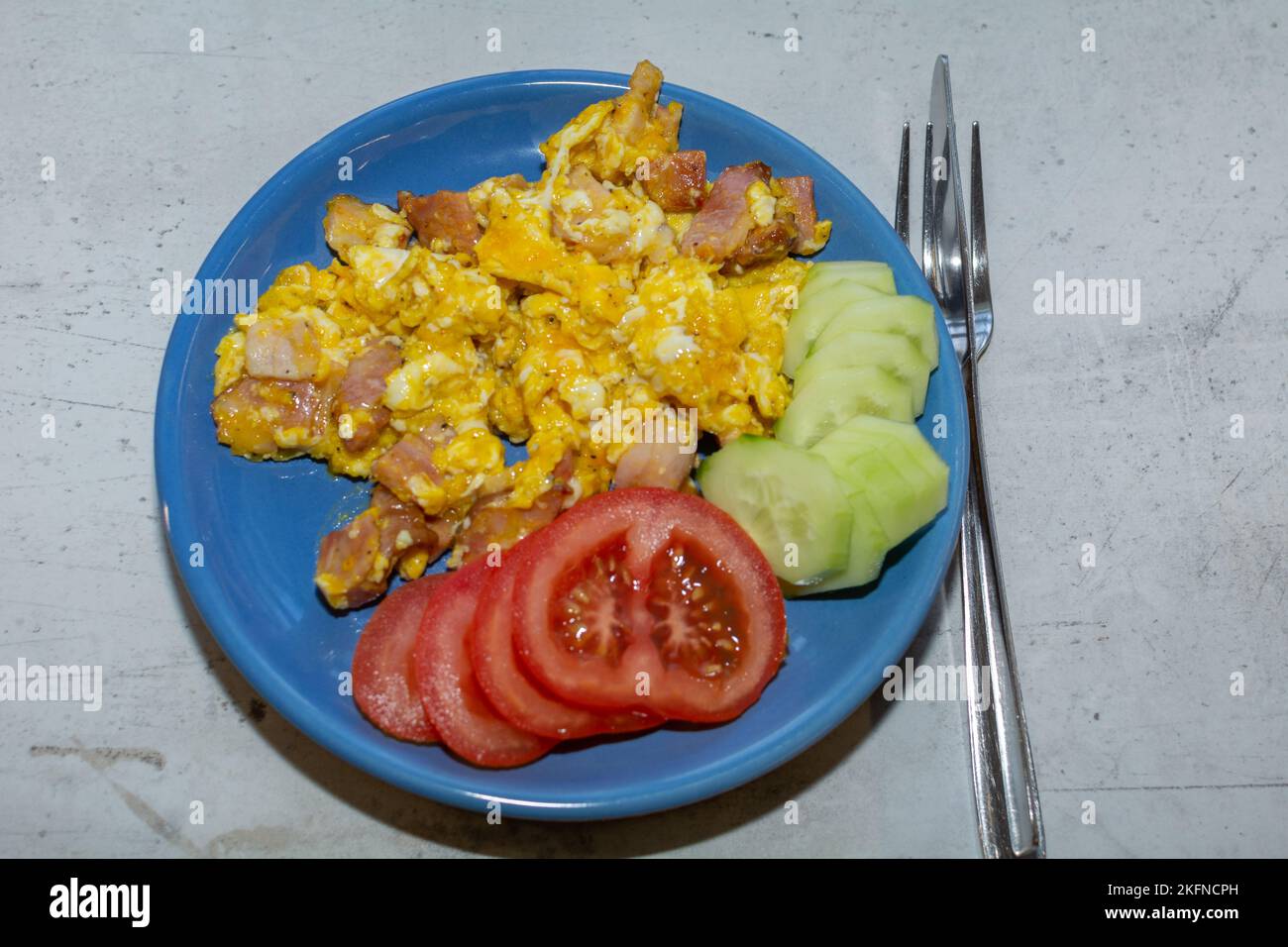 Scrambled eggs with bacon in a pan. Stock Photo