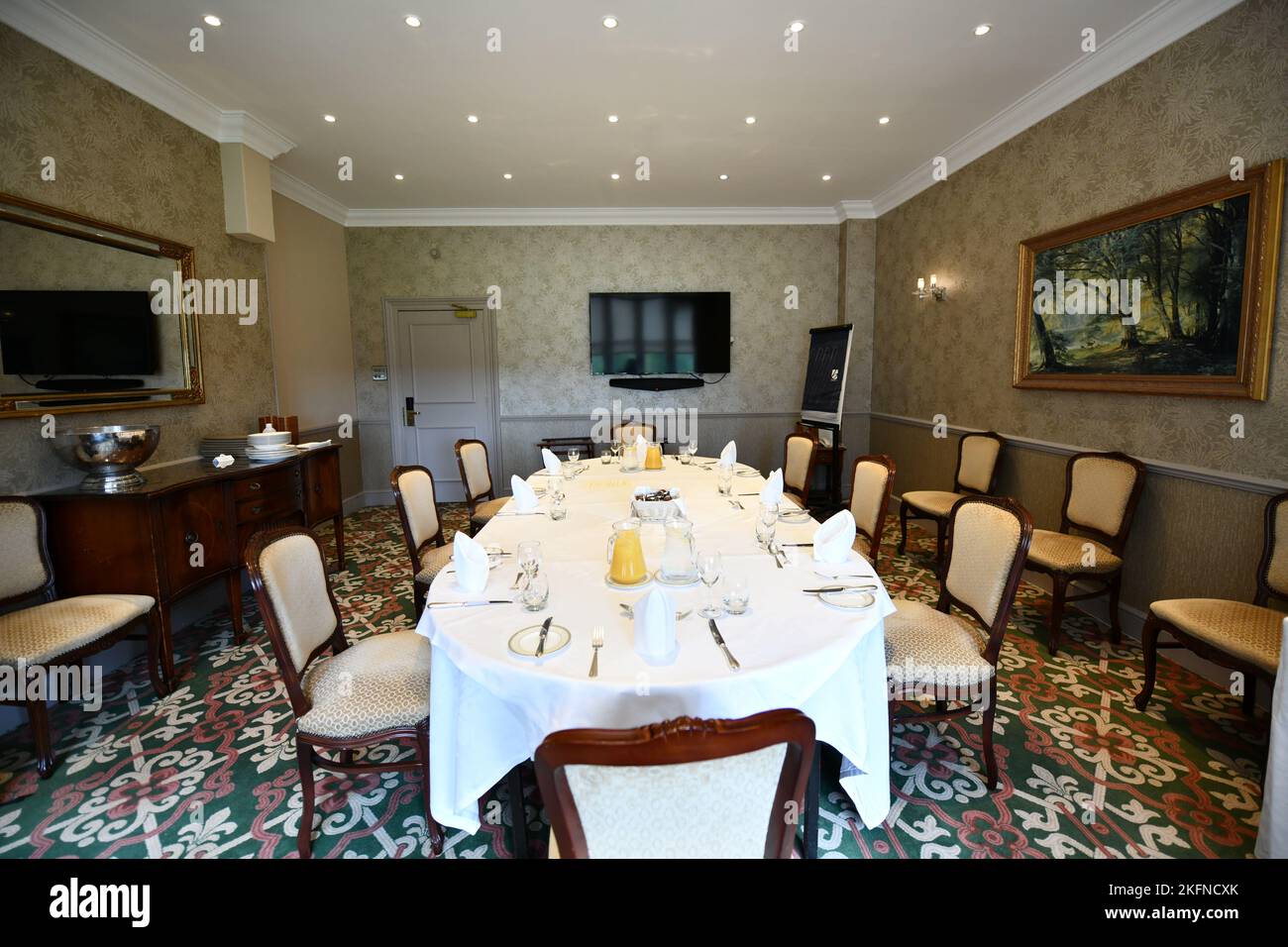 Large oval table set out for meeting in an old fashioned hotel ...