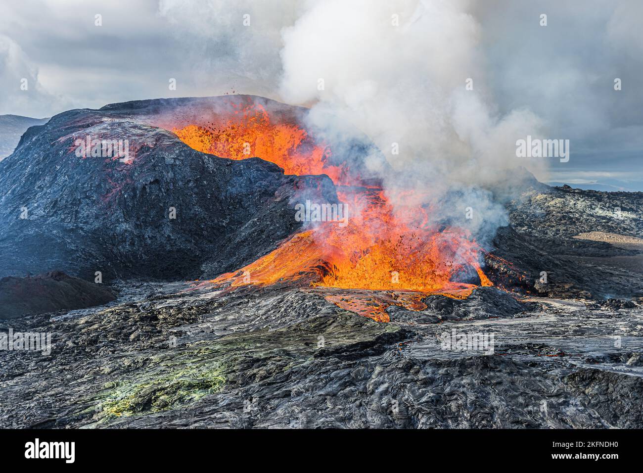 leveling off eruption from a volcanic crater. active volcano in the landscape in Geopark of Reykjanes Peninsula. glowing hot lava flows from volcano Stock Photo