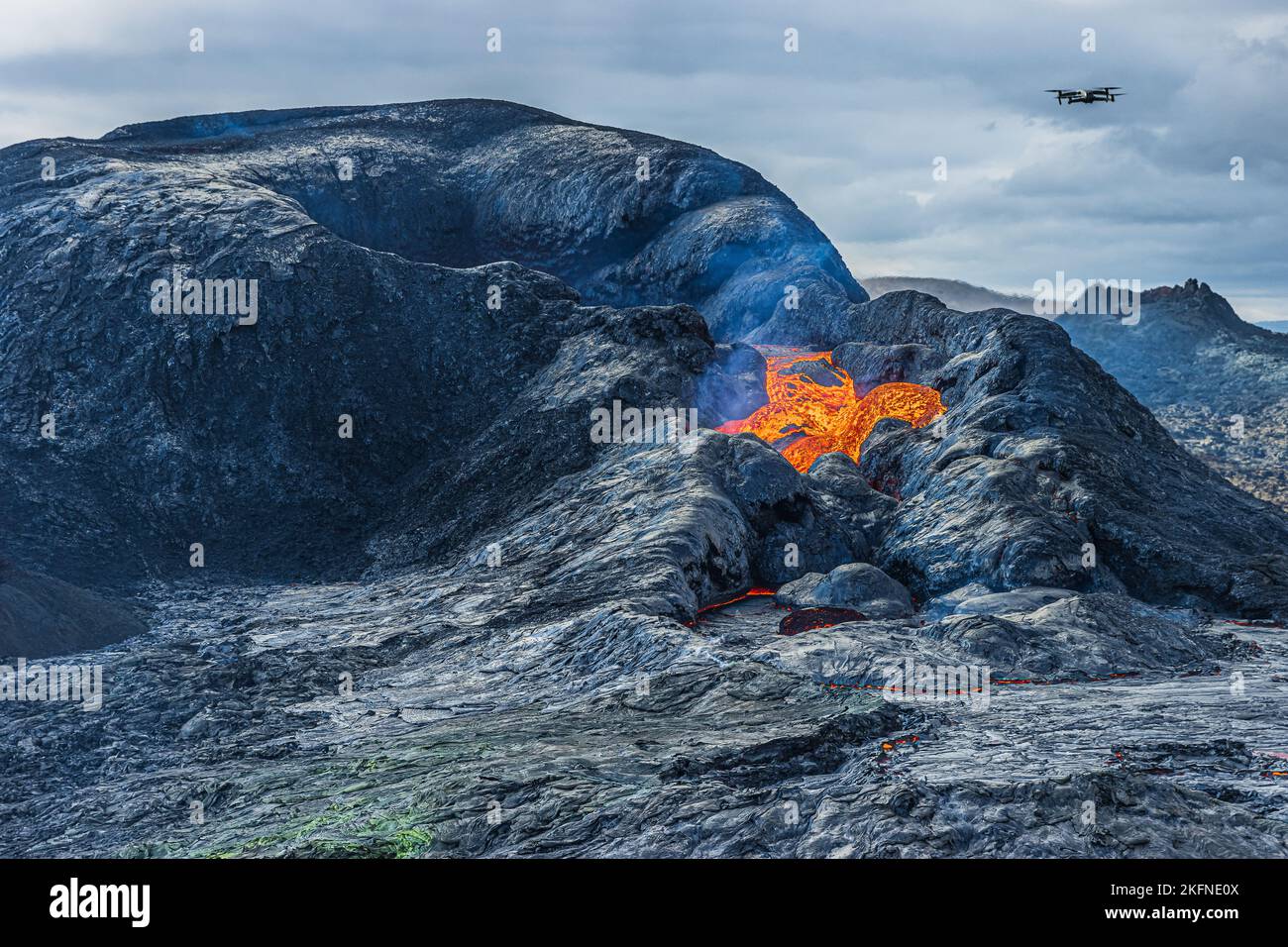 Opening of a volcanic crater during the day. crater mouth with incipient eruption with some lava flow. volcanic landscape on iceland of reykjanes Stock Photo
