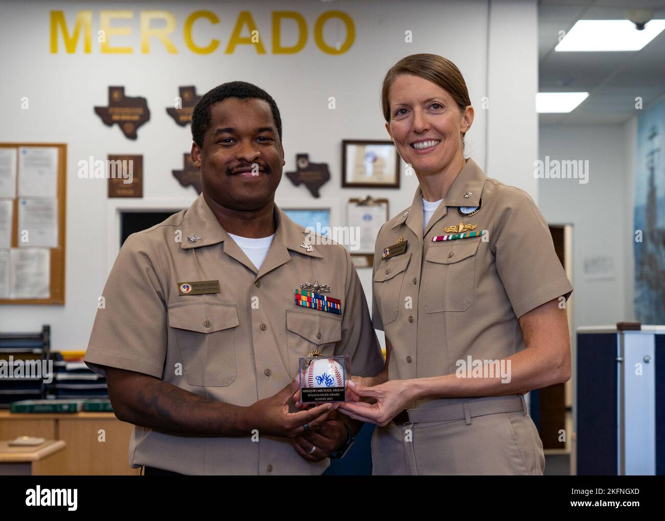 SAN ANTONIO - (Sept. 28, 2022) Members of Navy Talent Acquisition Group (NTAG) San Antonio’s Division Five gathered at Navy Recruiting Station (NRS) Mercado for an awards luncheon provided by the command in recognition of their exceptional performance. Machinist Mate Second Class Petty Officer Michael Okray is presented with the Texas Ranger Award for August 2022 by NTAG San Antonio Commanding Officer, CDR. Stephanie Simoni. Stock Photo