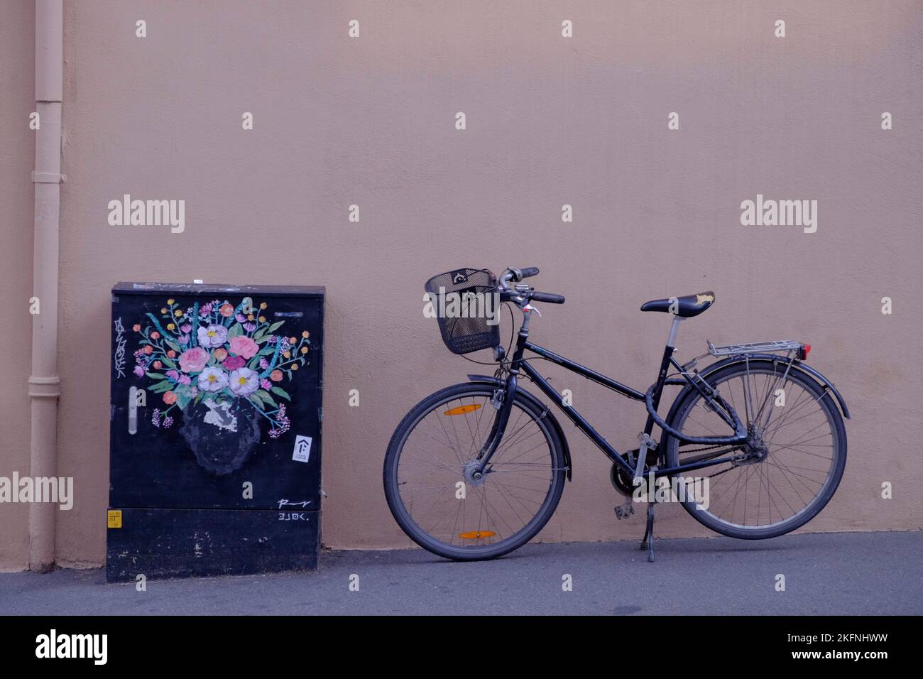 A bicycle in front of a creamcolored wall with beautiful street art Stock Photo Alamy