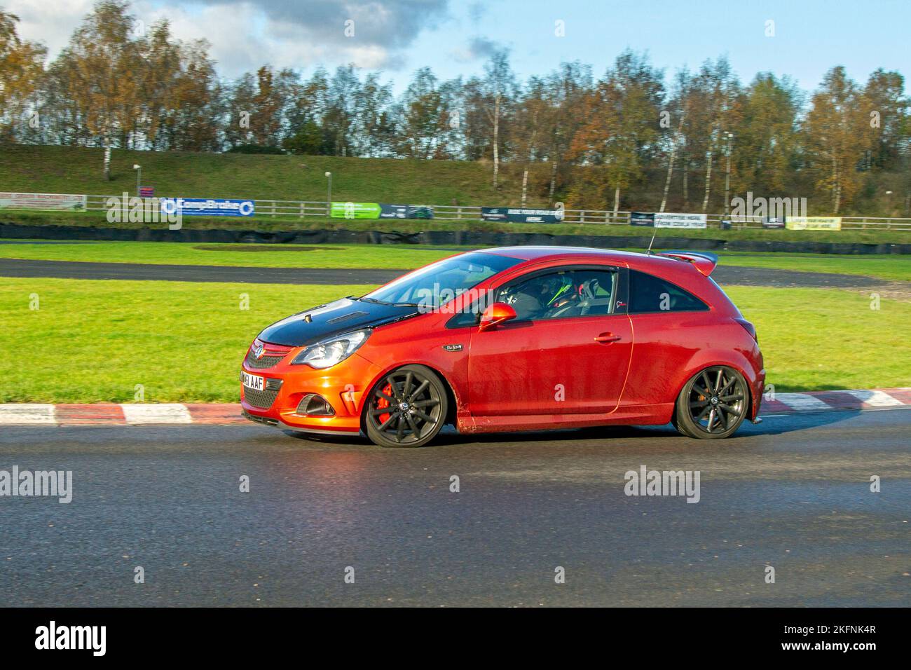 2012 Orange VAUXHALL CORSA VXR NURBURGRING EDITION 1598cc 6 speed manual; driving on challenging high-speed and technical low-geared corners of the Three sisters race circuit near Wigan, UK Stock Photo