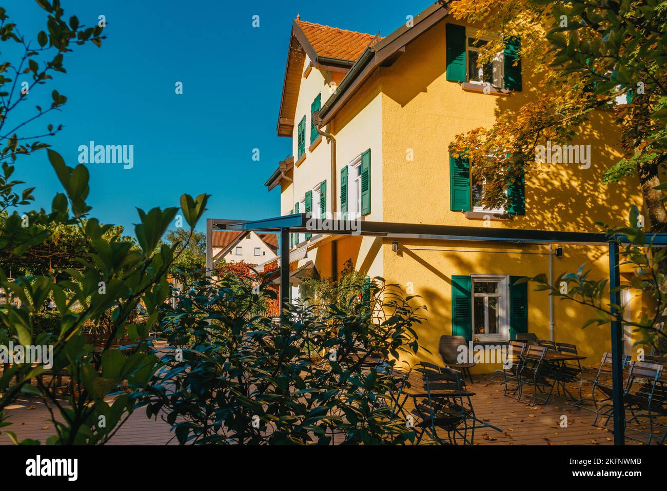 Image of a empty coffee tables arranged in backyard of a house. Autumn