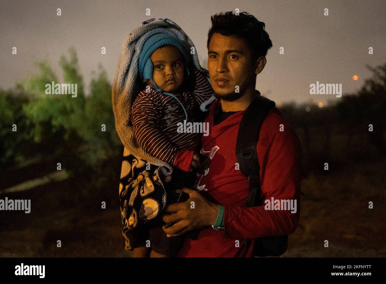 Edgar, an asylum seeking migrant from Honduras, holds his two year old son Liam as he awaits to surrender to border agents after being smuggled across the Rio Grande river from Mexico into Roma, Texas, U.S., November 18, 2022.  REUTERS/Adrees Latif     TPX IMAGES OF THE DAY Stock Photo