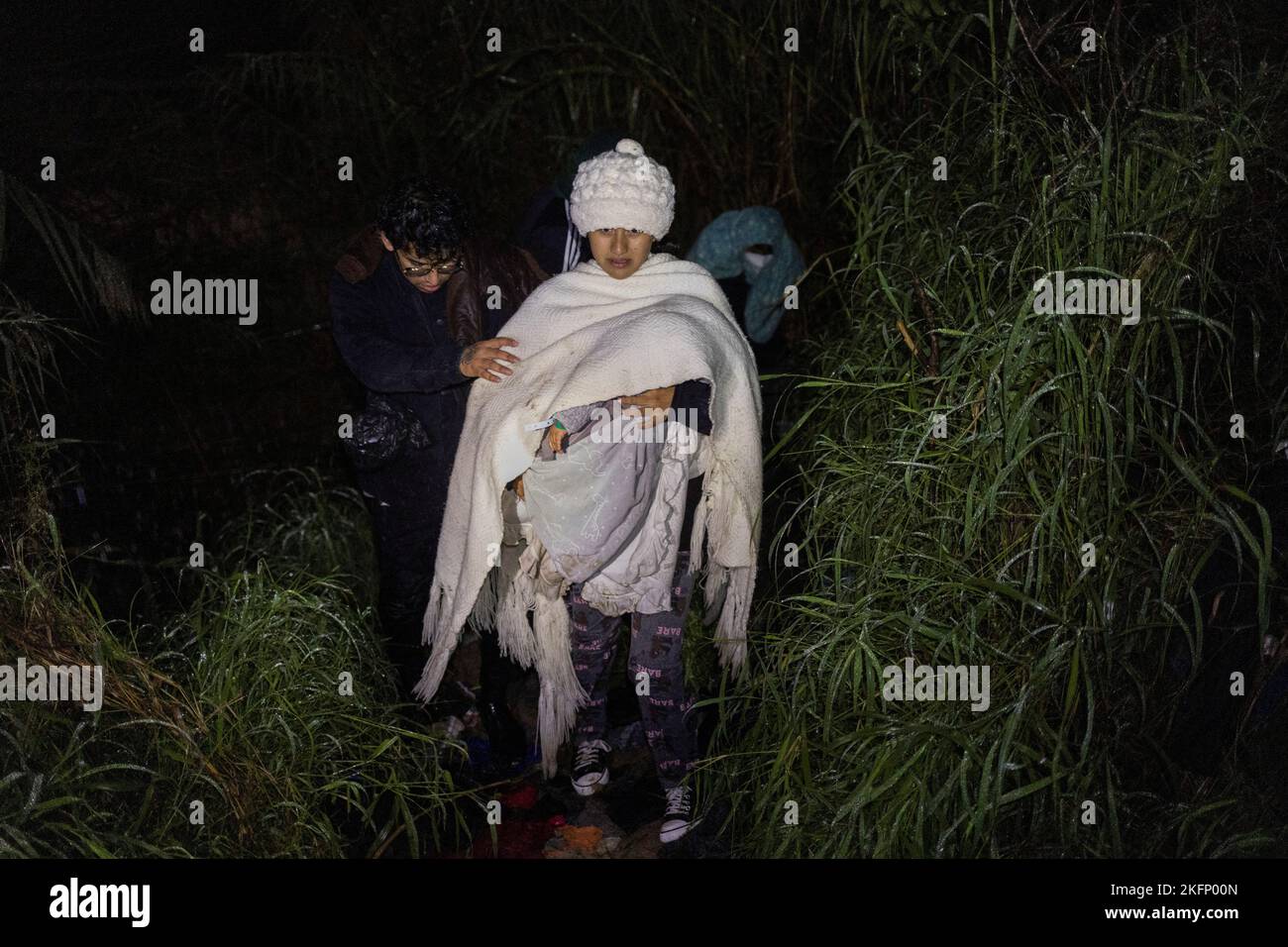 A color coded plastic band used by cartels and smugglers to track paying migrants is seen on the wrist of nine month old Valentino, of Peru, as he is carried by his mother Marbel and followed by his father Carlos, as they navigate thick brush and cold, wet weather after crossing the Rio Grande river from Mexico into Roma, Texas, U.S., November 18, 2022.  REUTERS/Adrees Latif     TPX IMAGES OF THE DAY Stock Photo