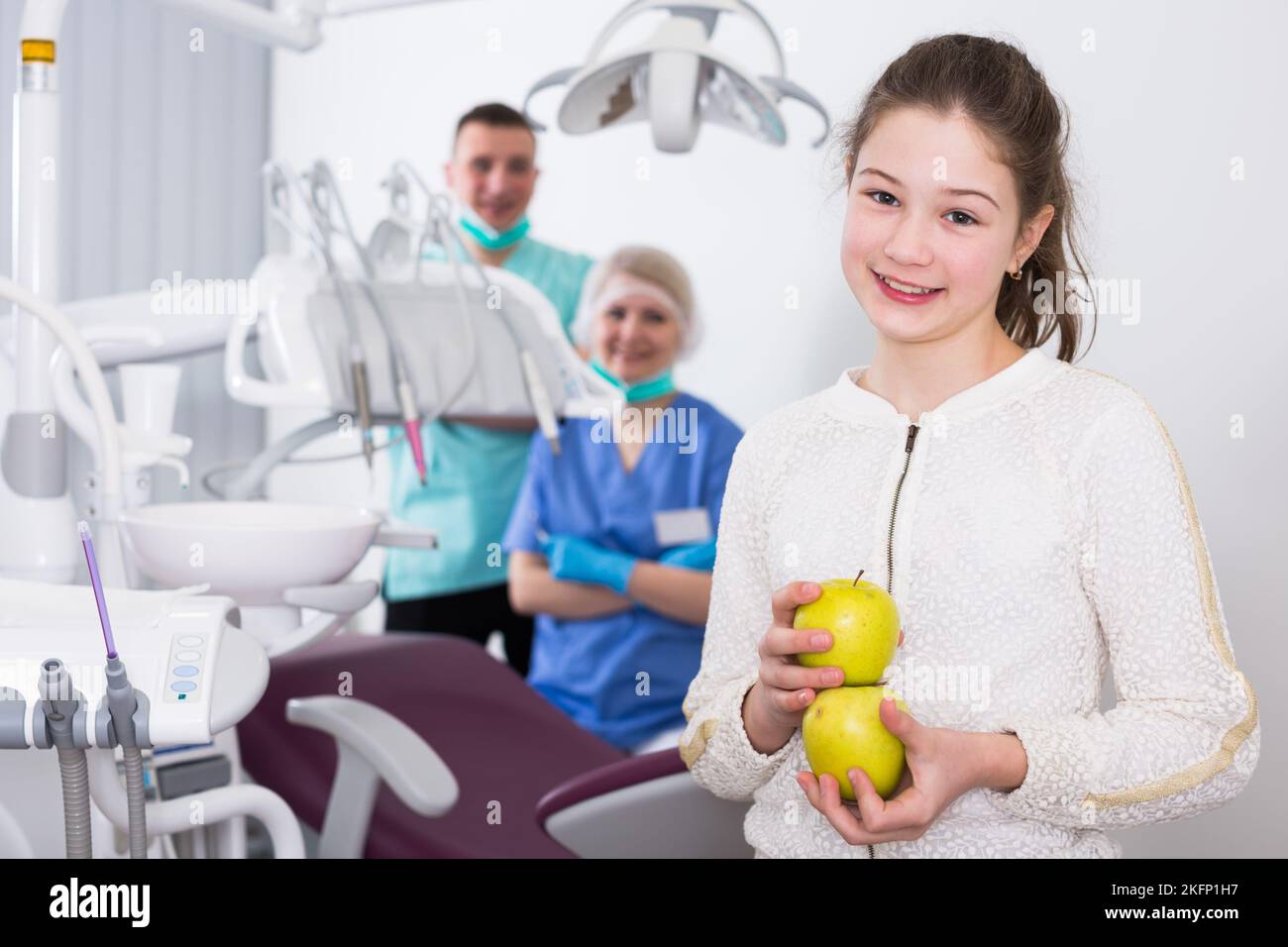 Happy girl with apples in dental clinic Stock Photo