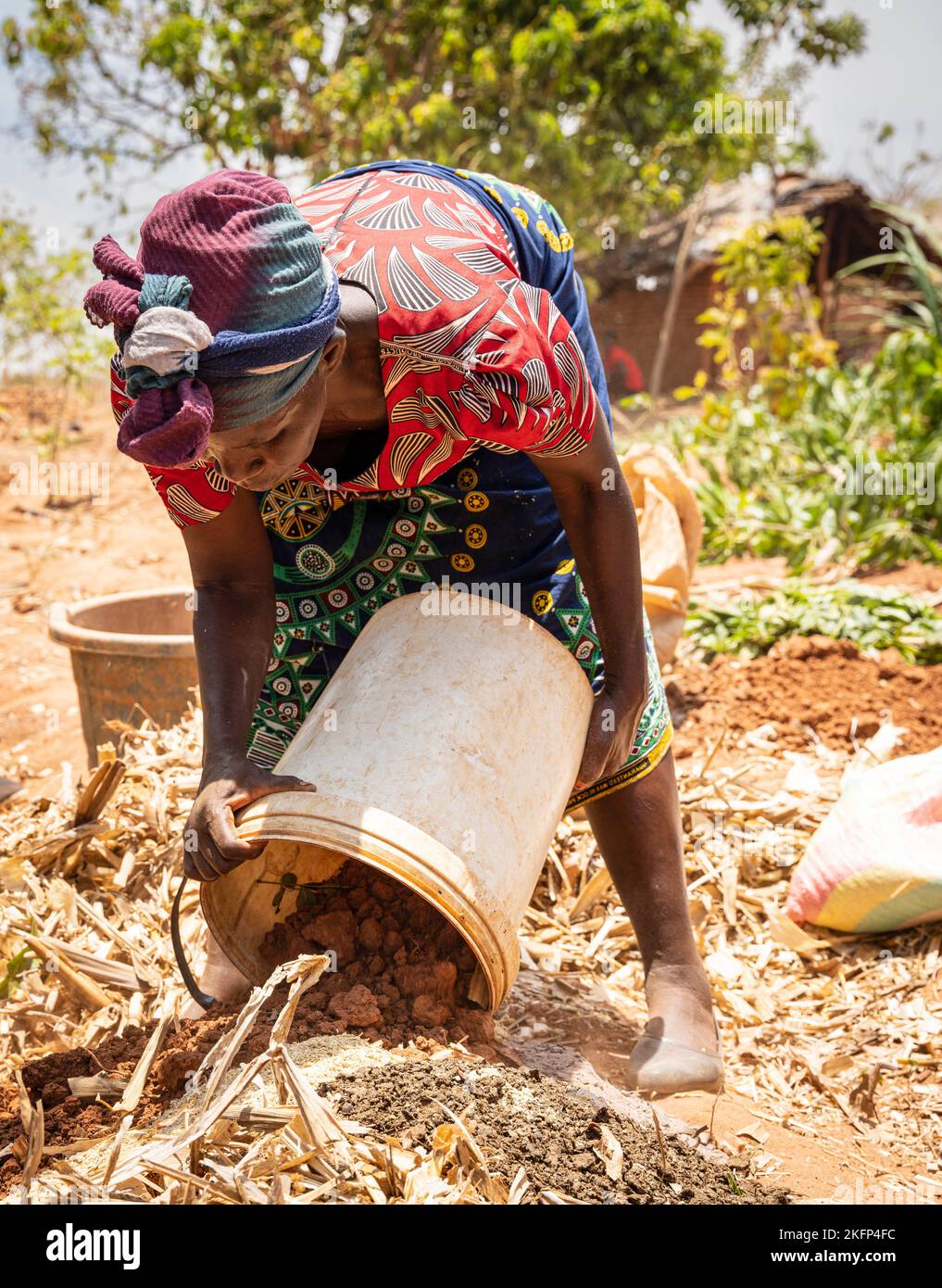 A women farmer demonstrates how to make bokashi manure as part of a conservation agriculture package in rural Malawi Stock Photo