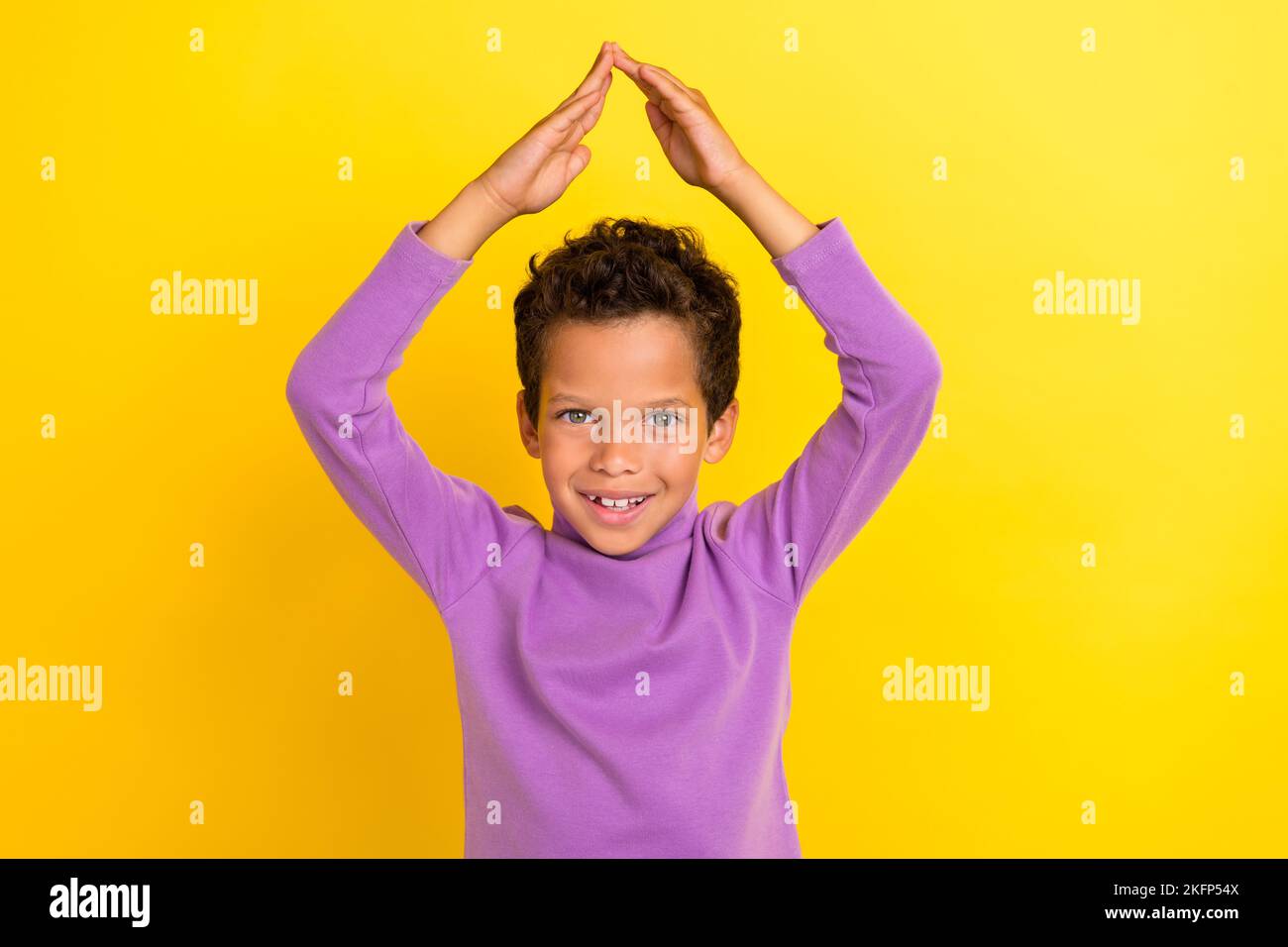 Photo portrait of adorable little pupil boy arms show roof safe home house wear trendy violet clothes isolated on yellow color background Stock Photo