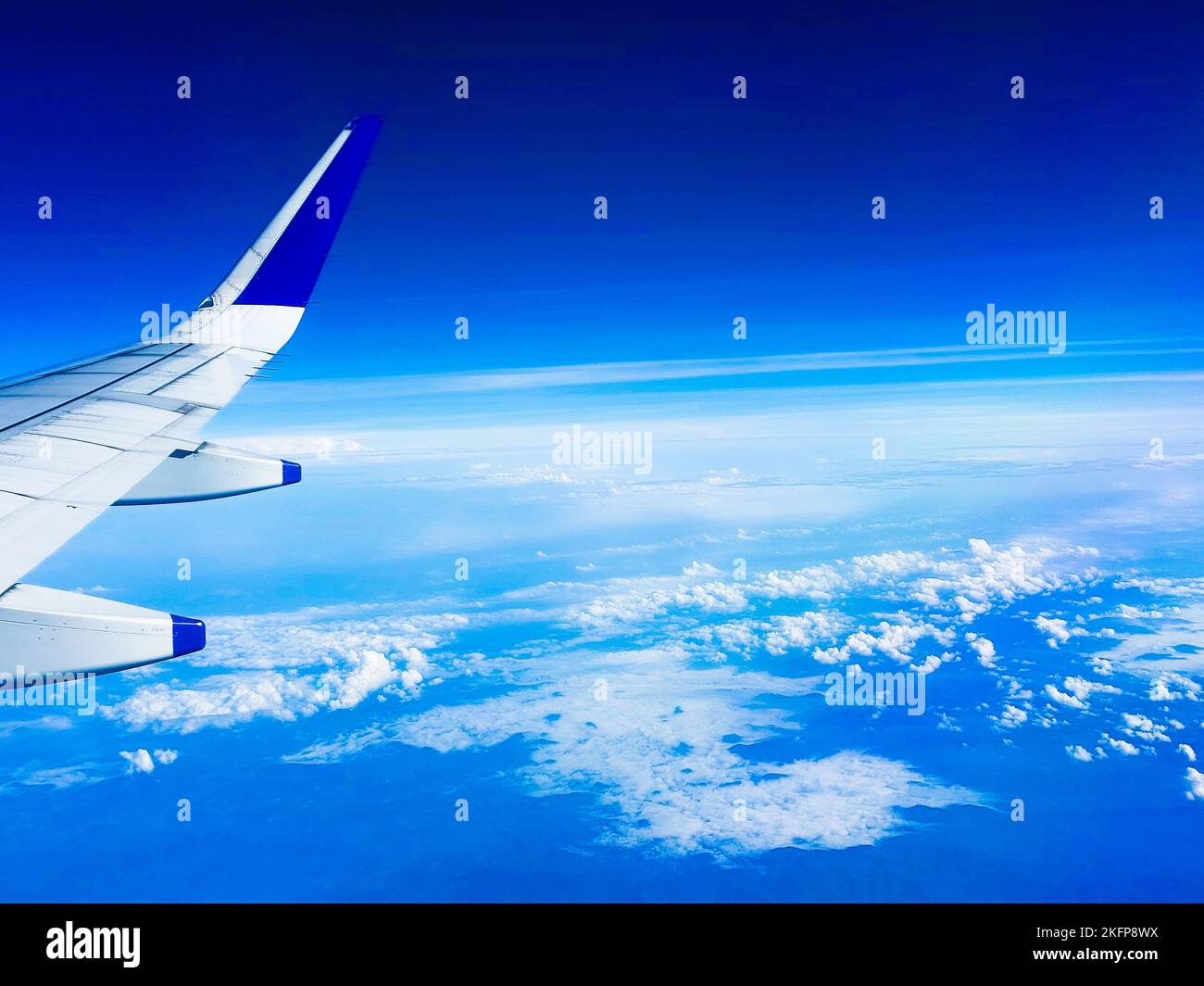 An airplane wing and a beautiful blue sky with white clouds Stock Photo ...