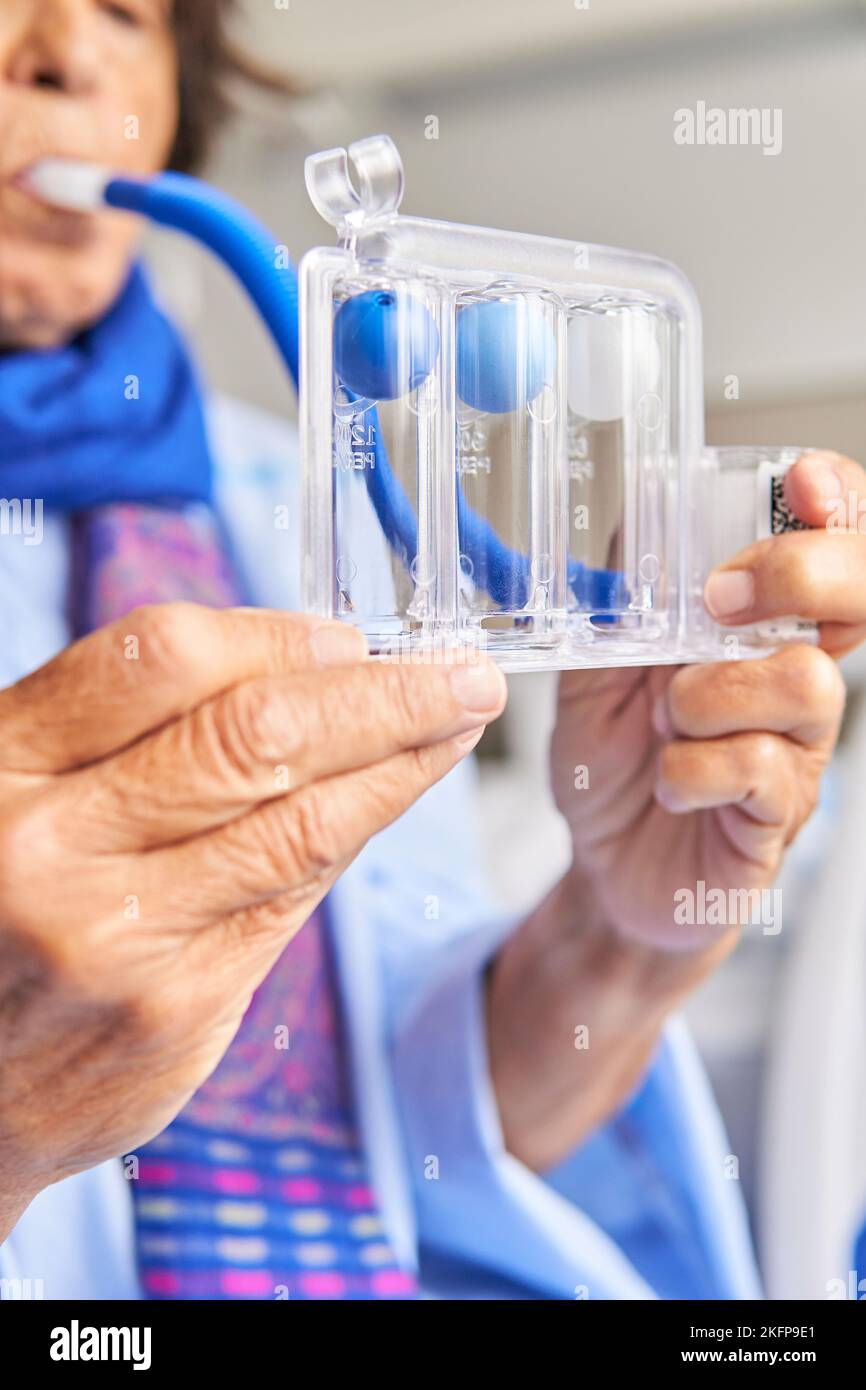 spirometer for breathing exercises. senior woman in hospital room