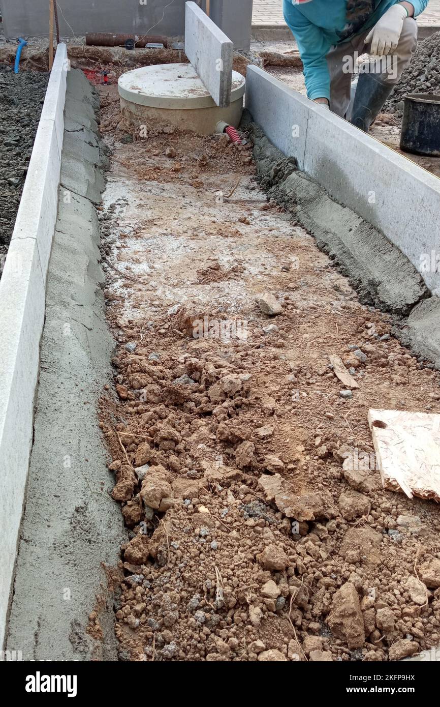 Workers carry out drainage works to drain the water around the house