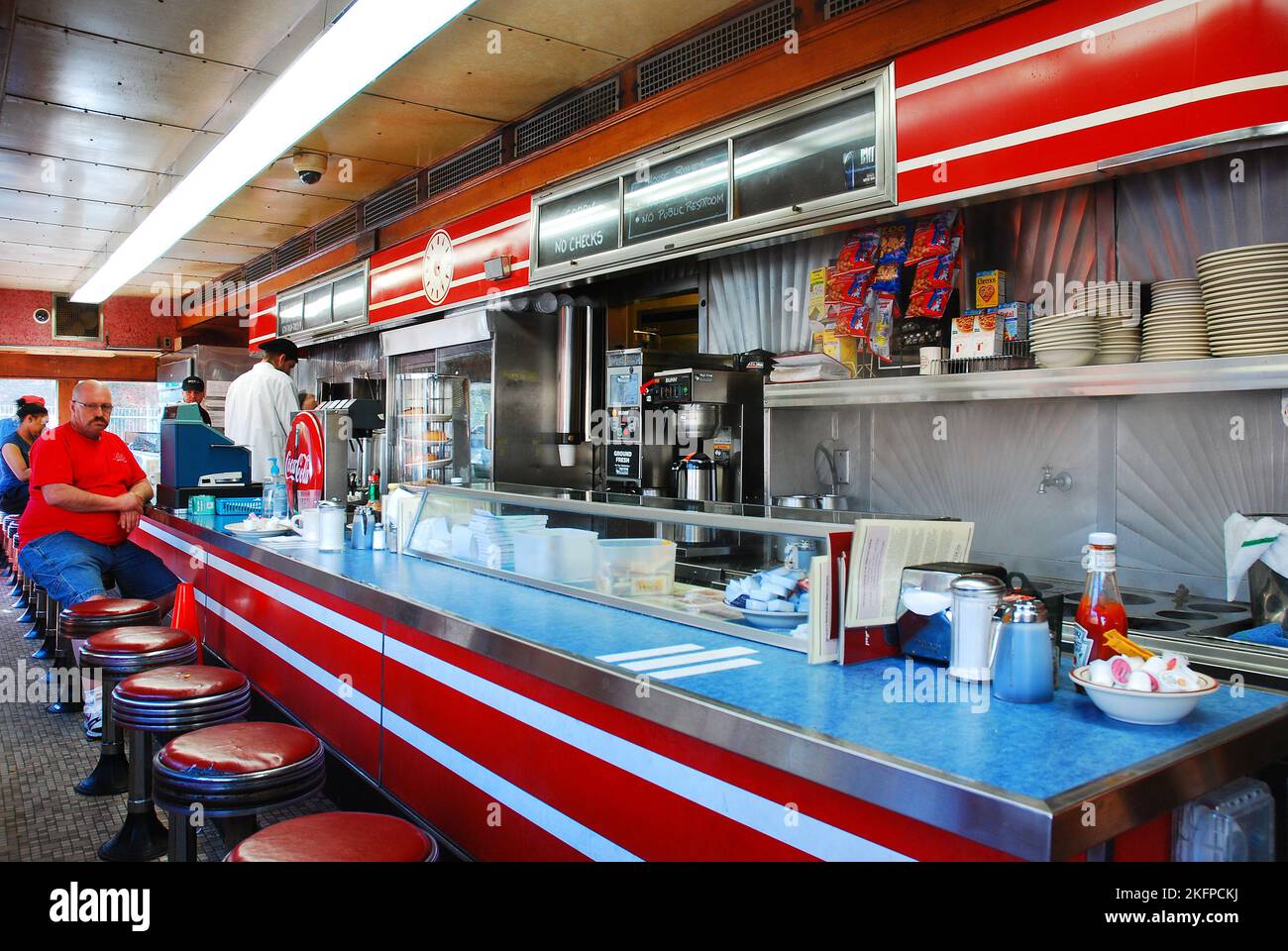 A man sits at the end of the counter, waiting for his order at Mickeys Dining Car, a classic O'Mahoney prefabricated diner, in St Paul Minnesota Stock Photo
