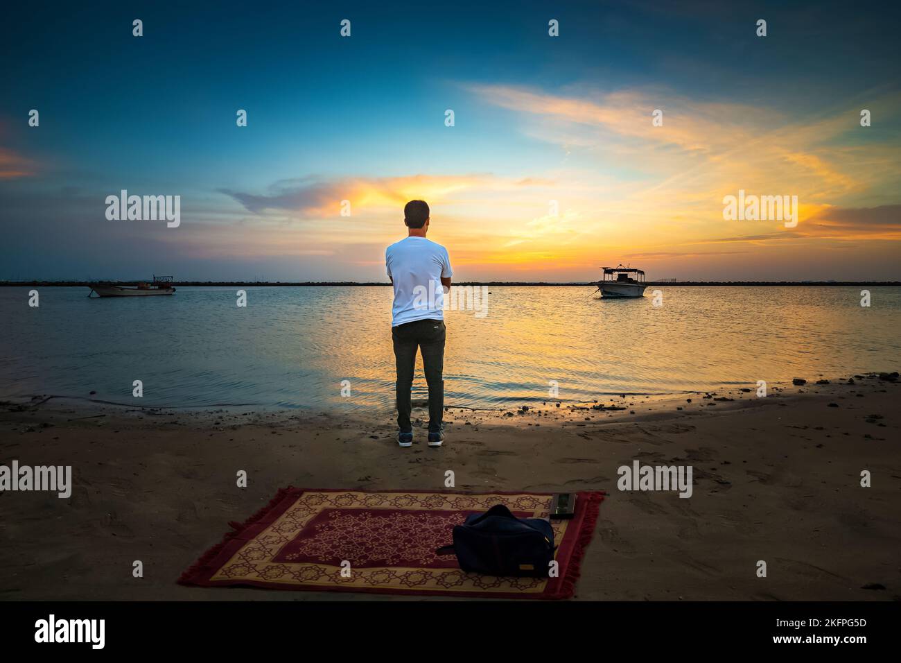 Man standing and watching sunset over the sea. Dammam, Saudi Arabia ...