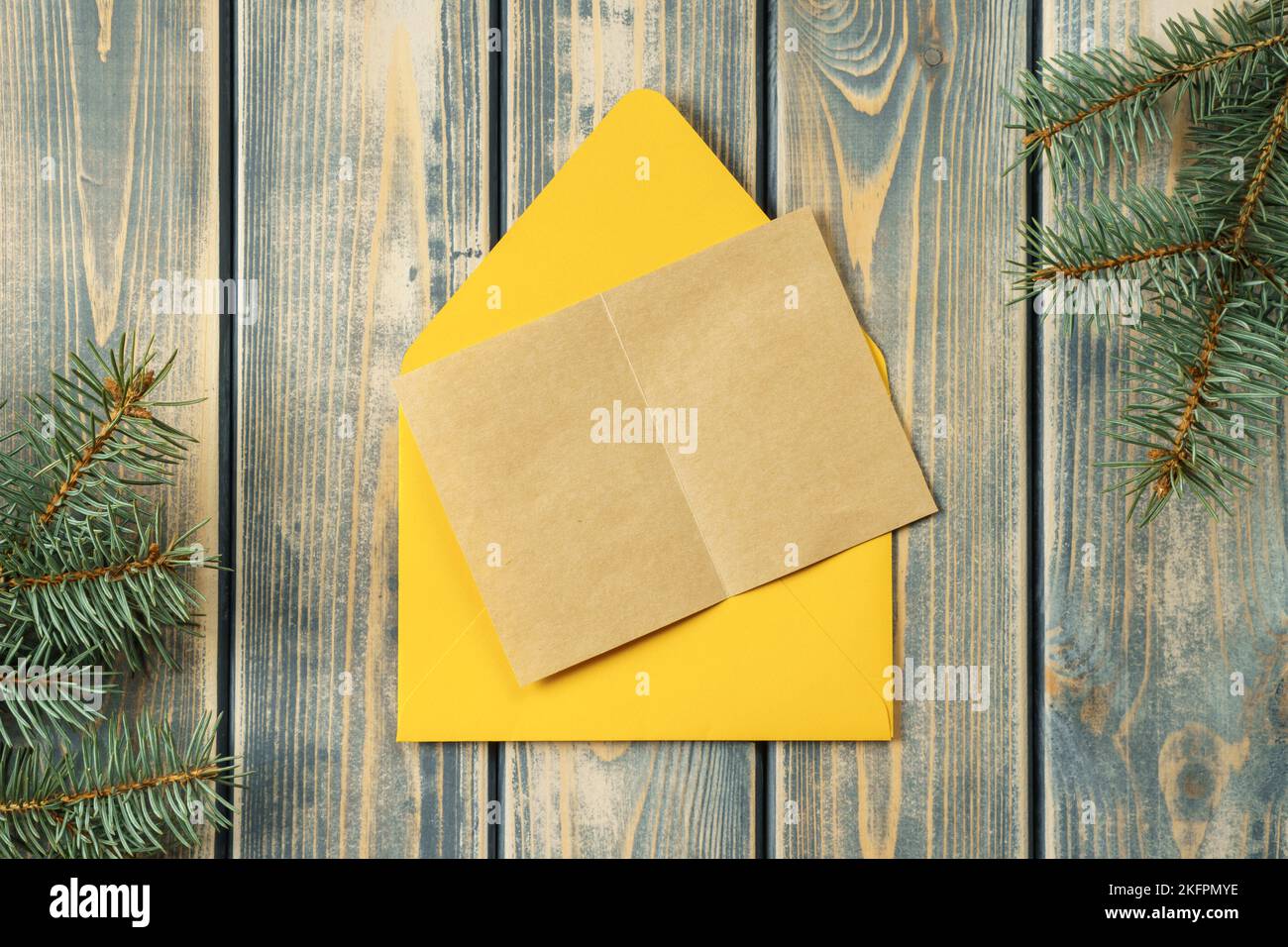 Yellow bright open envelope on gray wooden background with blank kraft ...