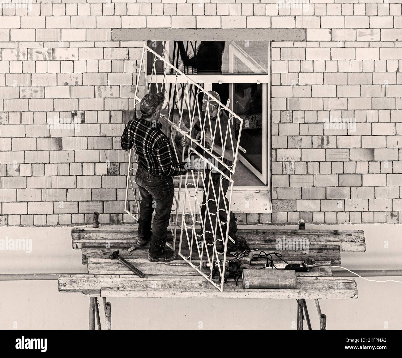 workers mounting the window grating Stock Photo - Alamy