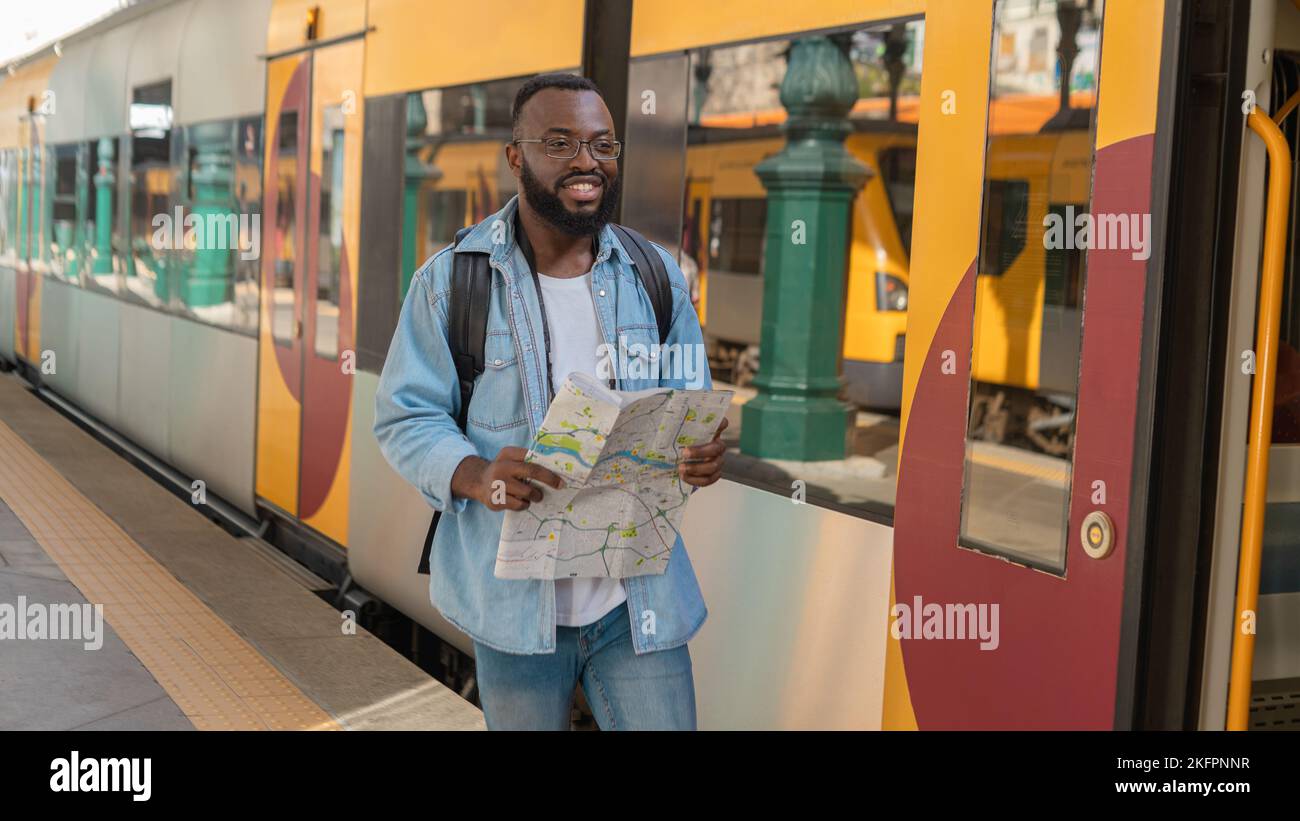 Young adult man with map at terminal train station Stock Photo