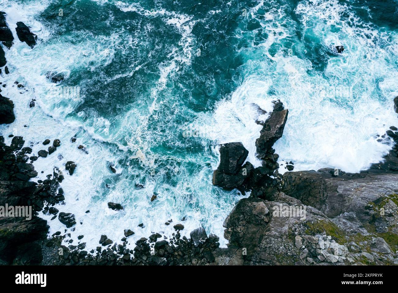 An aerial view of the sea waves crashing the rocky shore Stock Photo ...