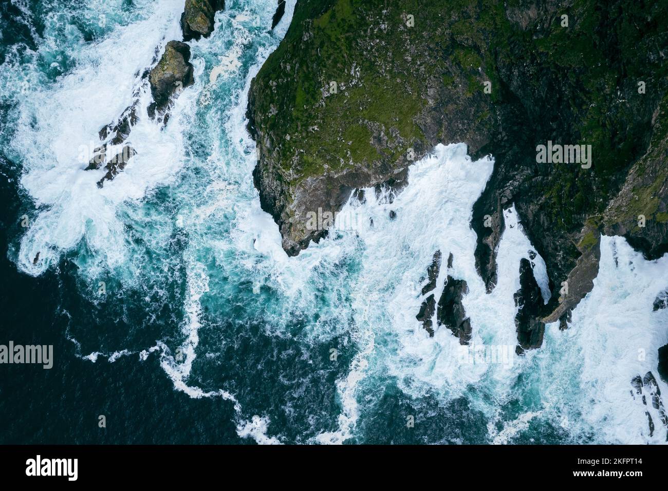 An aerial view of the sea waves crashing the rocky shore Stock Photo ...
