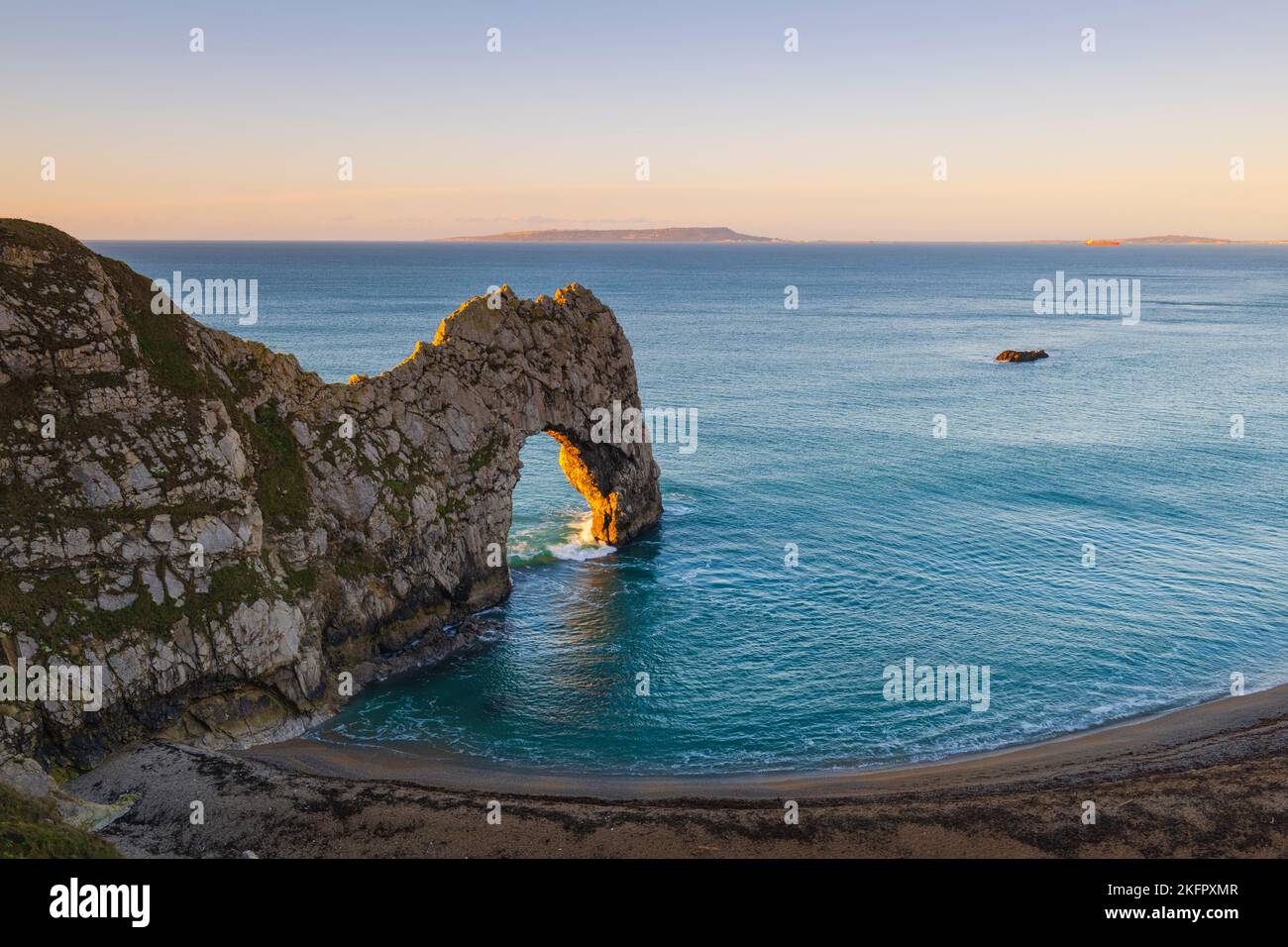 Early morning sunshine at Durdle Door on the Dorset Jurassic Coast, UK looking towards Portland on a cold, clear morning. 19th November 2022.  Picture Stock Photo