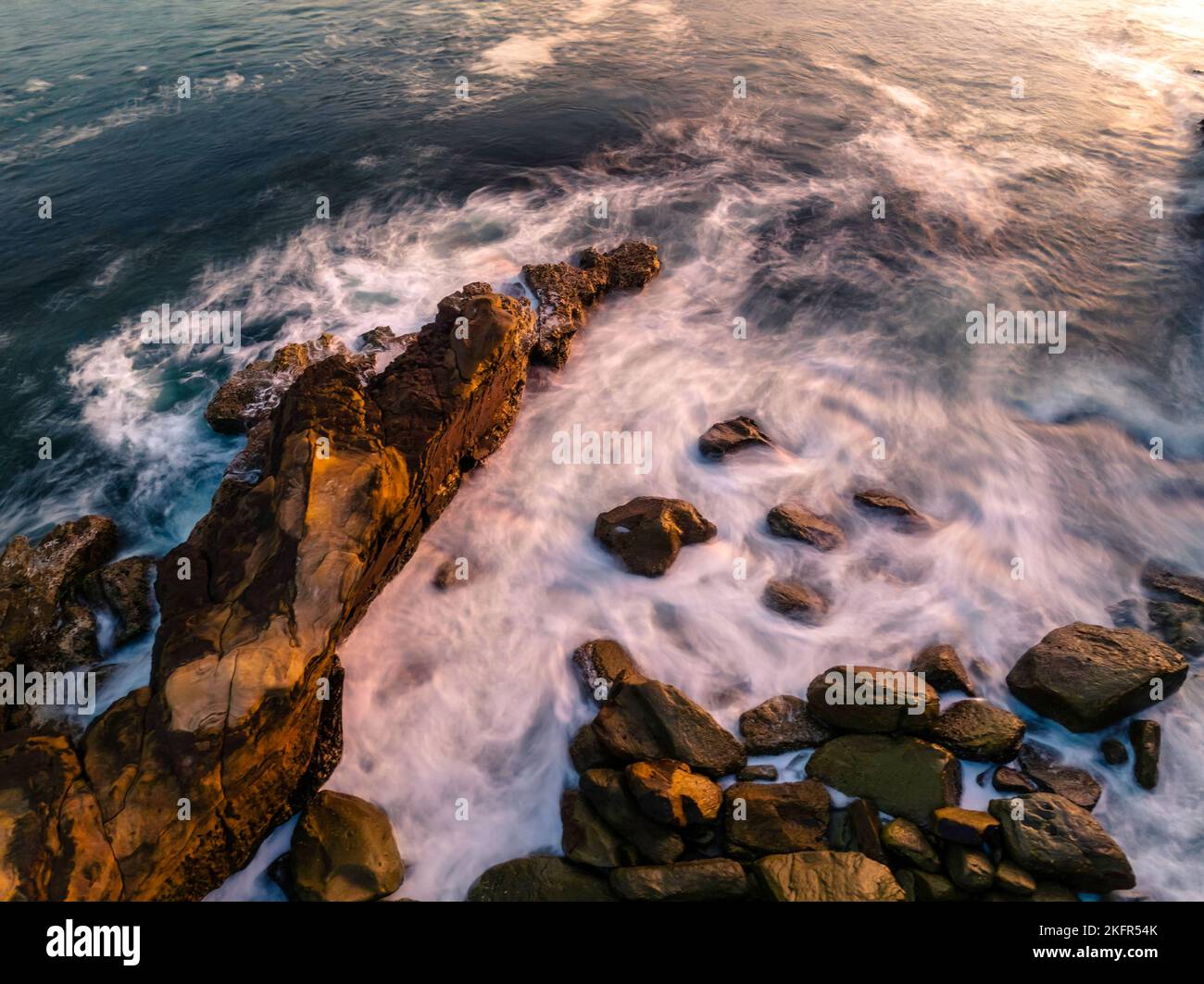 Aerial sunrise at the seaside with rocks and gentle surf at Avoca Beach on the Central Coast, NSW, Australia. Stock Photo