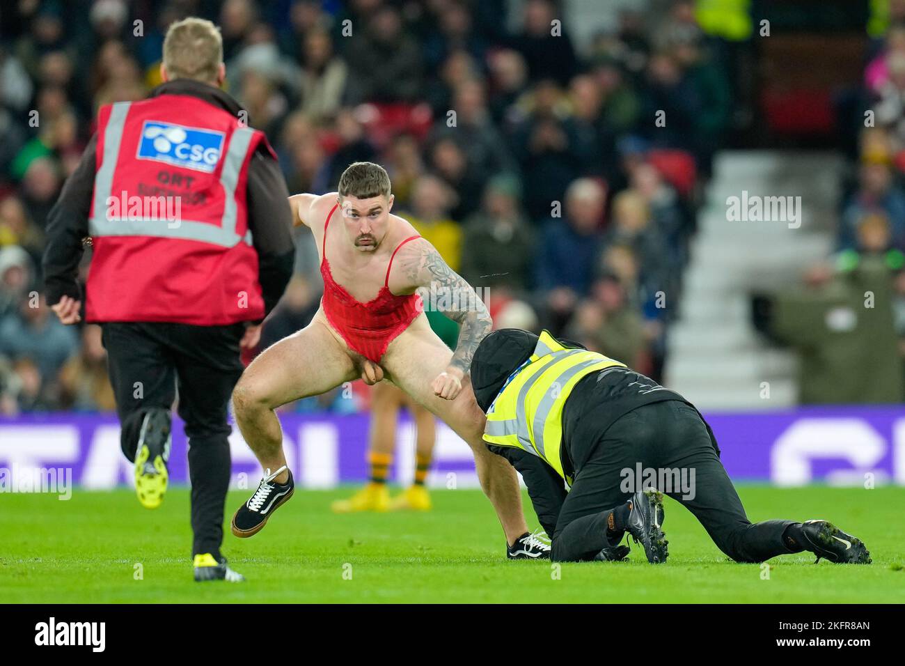 Manchester, UK. 18th Nov, 2022. Stewards attempt to stop a streaker during the 2021 Rugby League World Cup Final 2021 match between Australia and Samoa at Old Trafford, Manchester, England on 19 November 2022. Photo by David Horn. Credit: PRiME Media Images/Alamy Live News Stock Photo