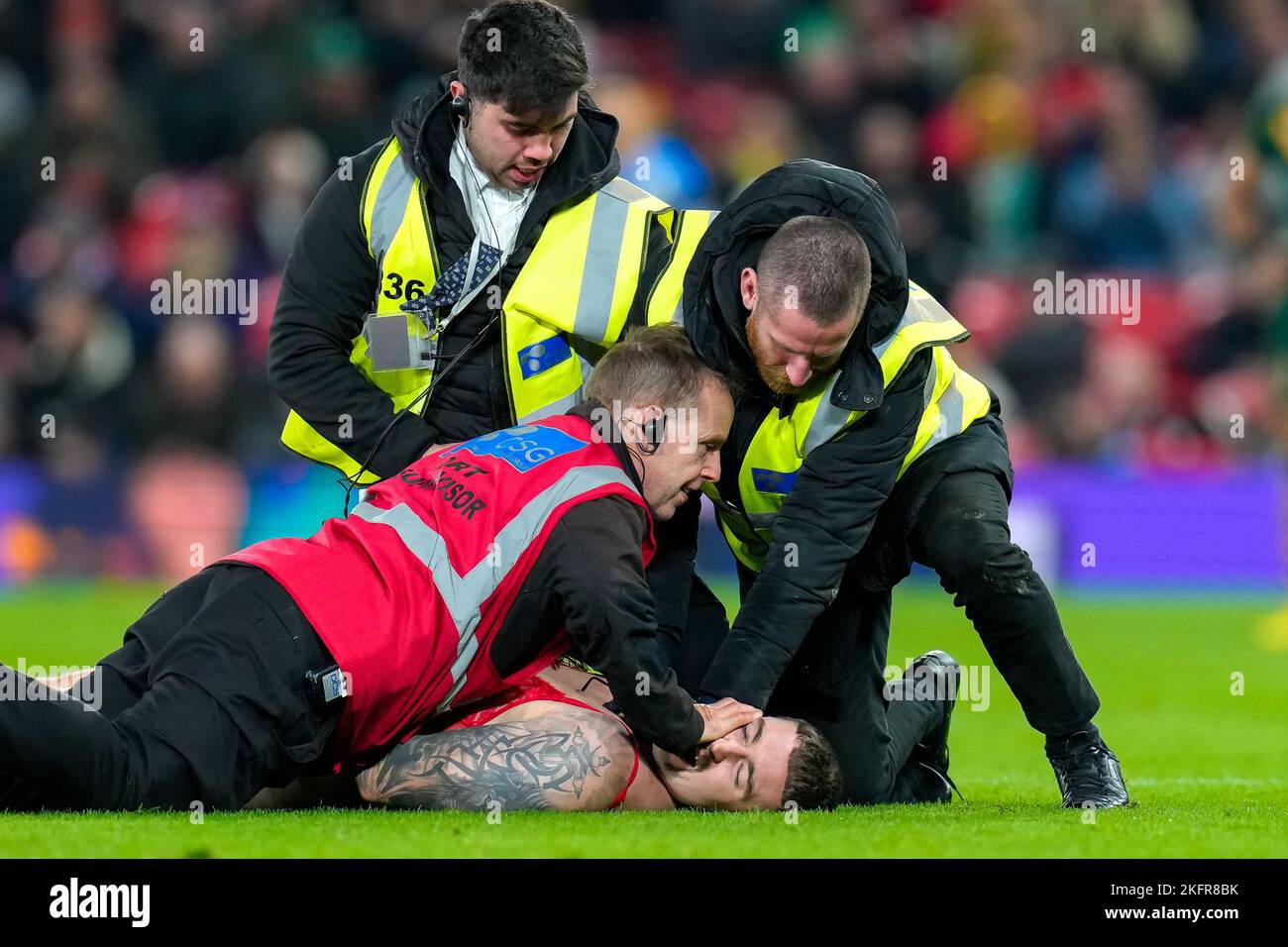 Manchester, UK. 18th Nov, 2022. Stewards restrain a streaker during the 2021 Rugby League World Cup Final 2021 match between Australia and Samoa at Old Trafford, Manchester, England on 19 November 2022. Photo by David Horn. Credit: PRiME Media Images/Alamy Live News Stock Photo
