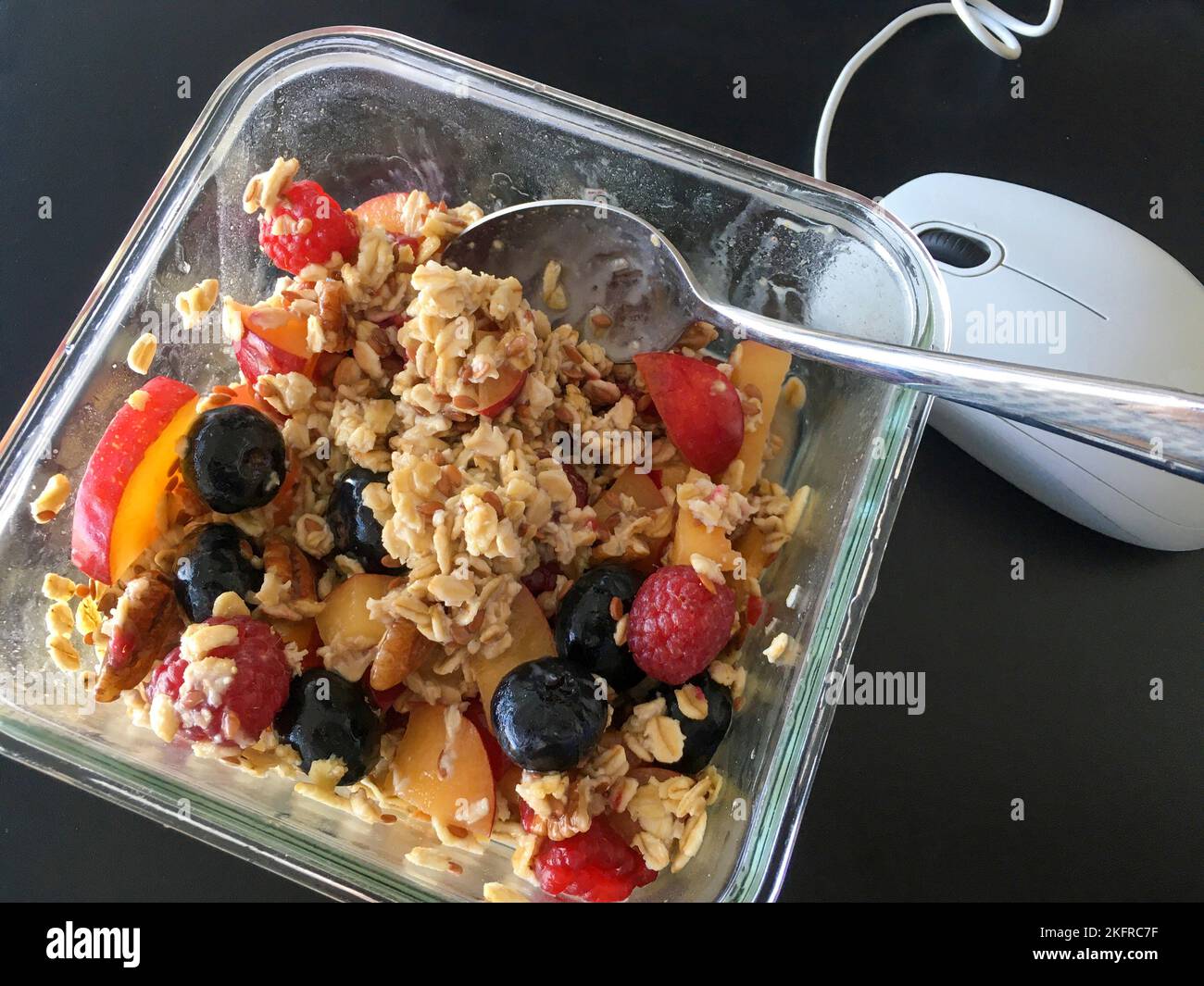Müsli mit Früchten, Nüssen und Haferflocken auf dem Schreibstisch Stock Photo