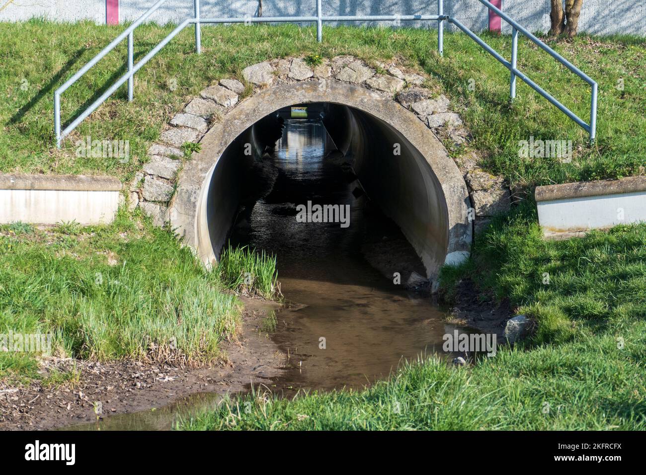 Abwasserkanal, Tunnel mit Spiegelung und Licht am Ende Stock Photo