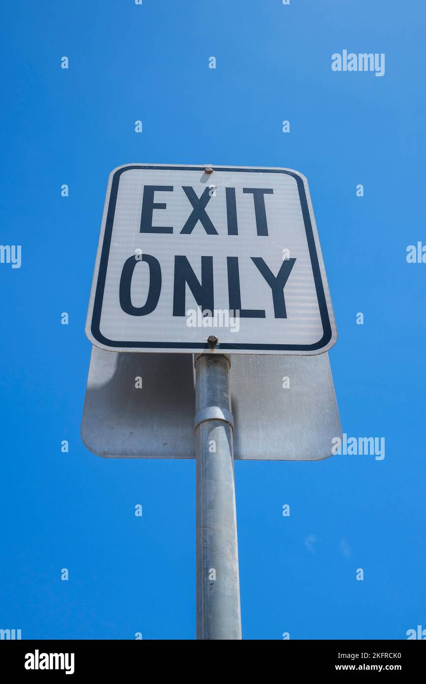 Exit Only road sign against clear blue sky Stock Photo