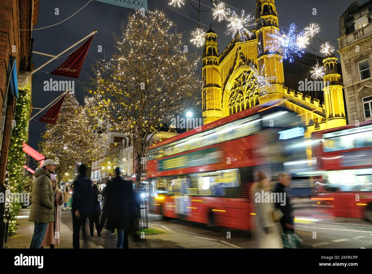 London, UK. 19th November, 2022. Buses pass Sloane Street with Christmas lights glittering behind. The Christmas light switch-on in King's Road attracted huge numbers of visitors to the surrounding area as people enter into the festive spirit. Credit: Eleventh Hour Photography/Alamy Live News Stock Photo